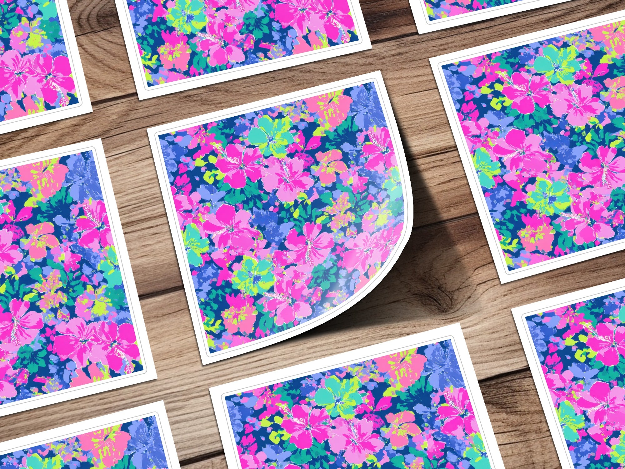 Floral sticker sheets with pink, blue, and green flowers on a wood background.