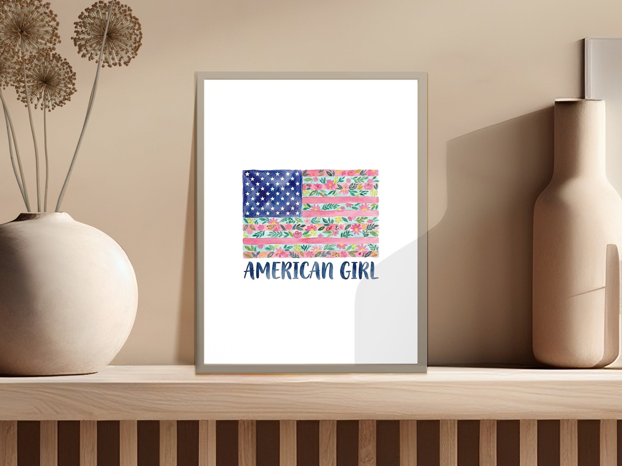 Floral American flag art with text "AMERICAN GIRL" on a shelf.