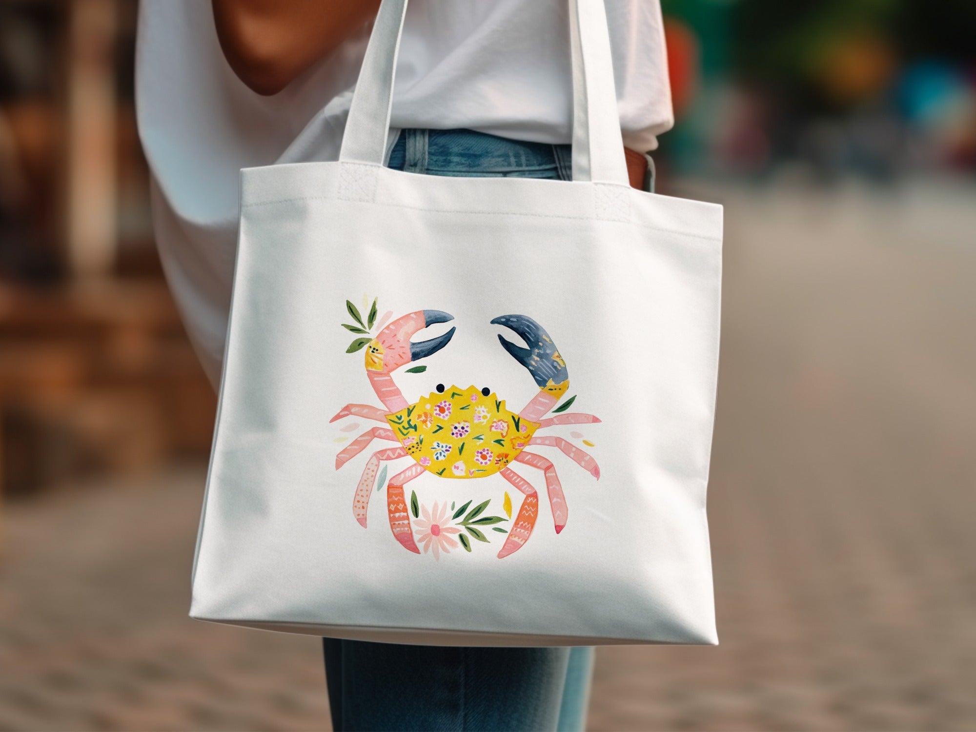 White tote bag with a colorful crab illustration and floral accents.