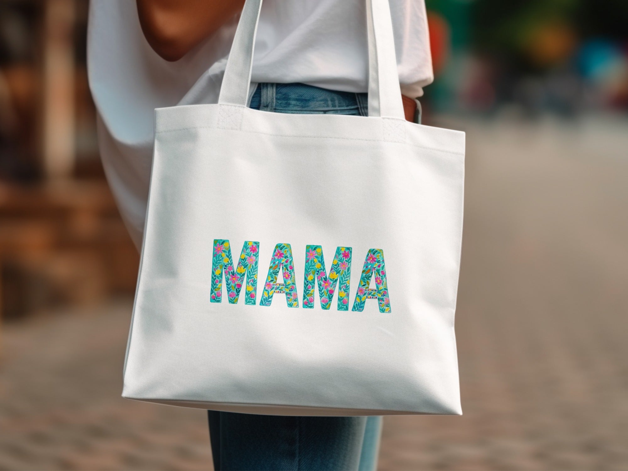 White canvas tote bag with colorful floral "MAMA" lettering.