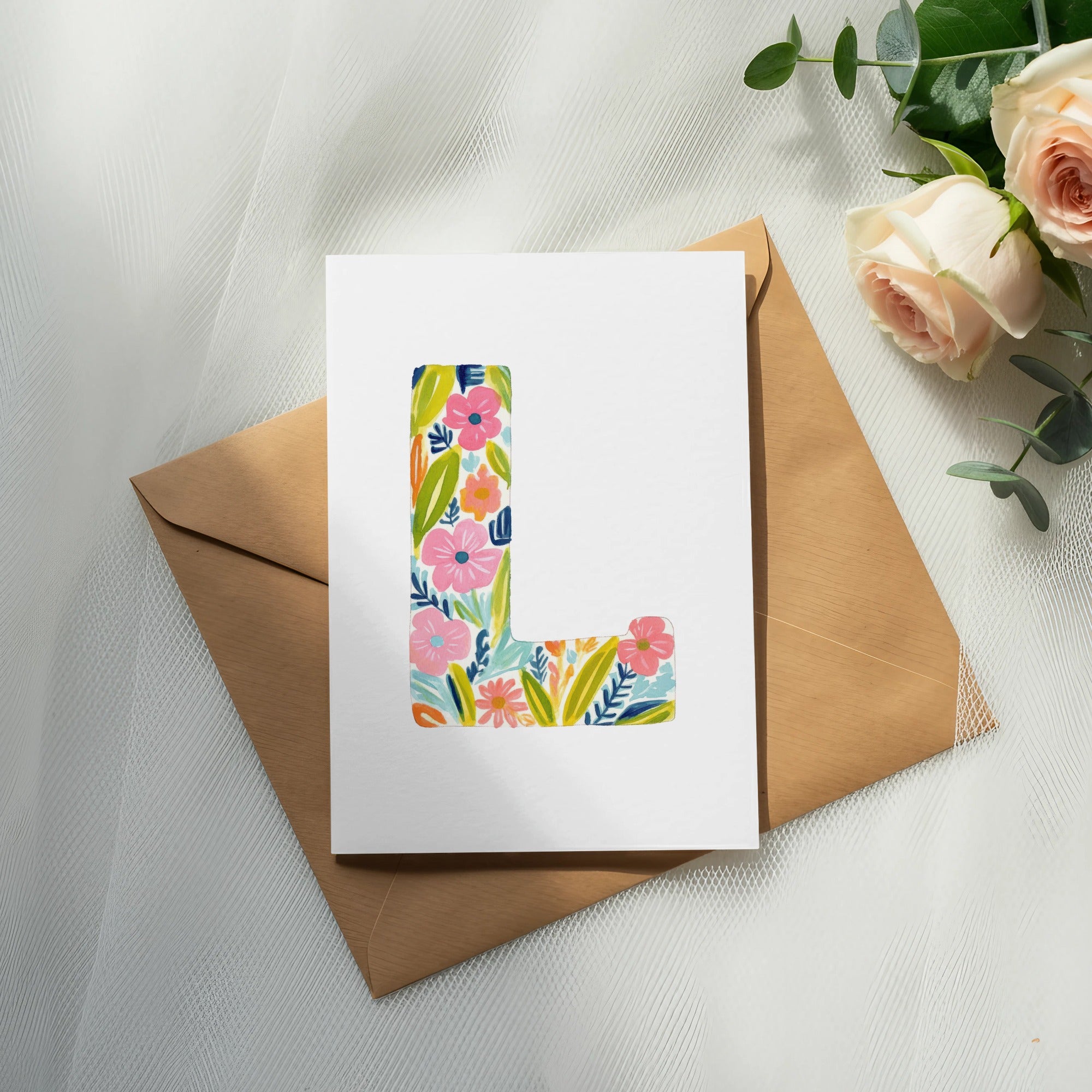Card with colorful floral initial 'L' on a brown envelope.