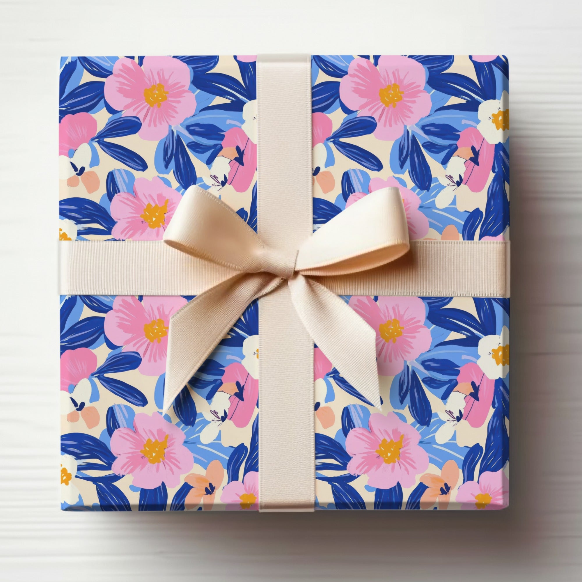 Gift box wrapped in floral paper with a tan ribbon bow.