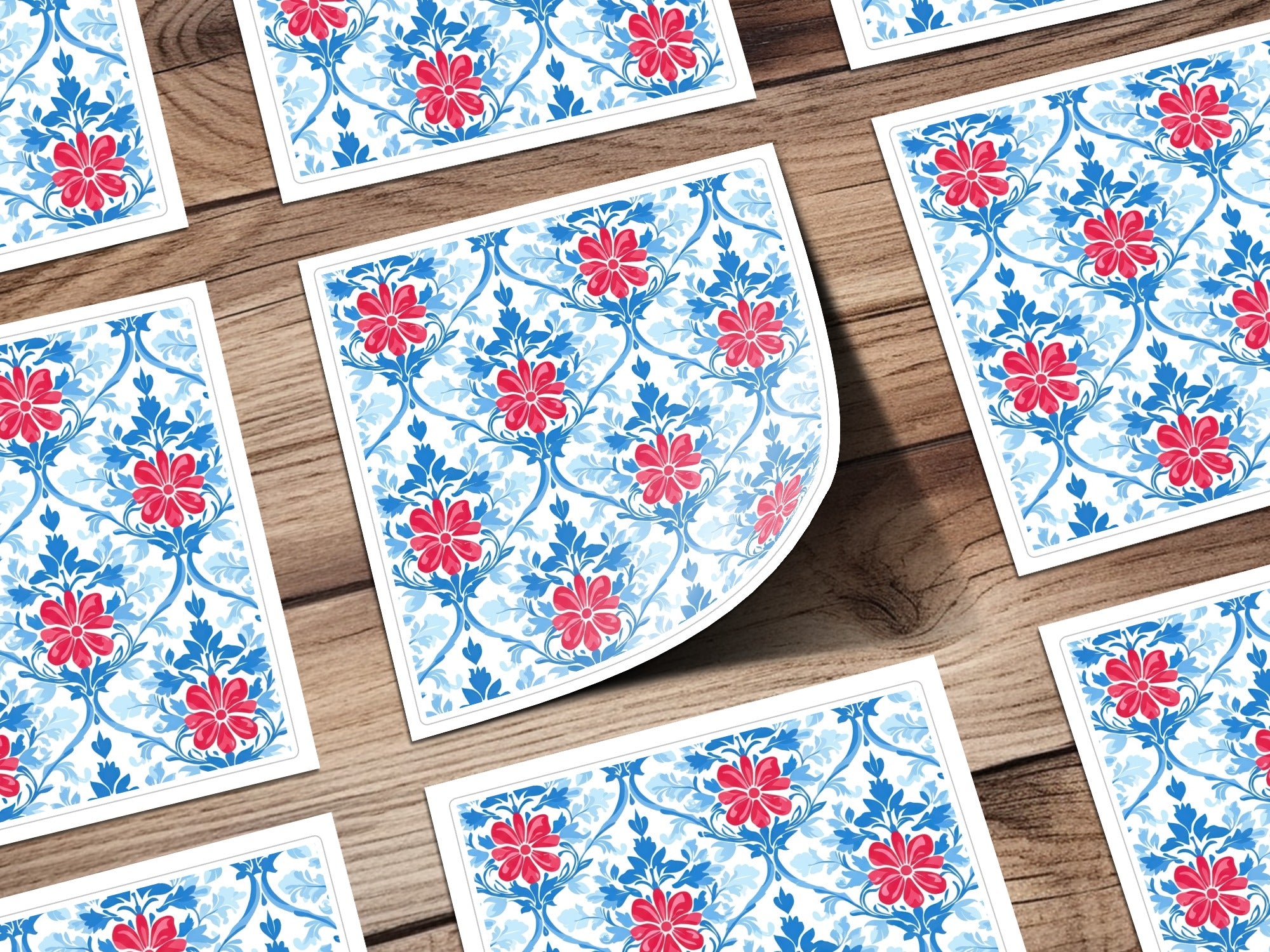 Blue and red floral pattern on white cards scattered on a wooden surface.