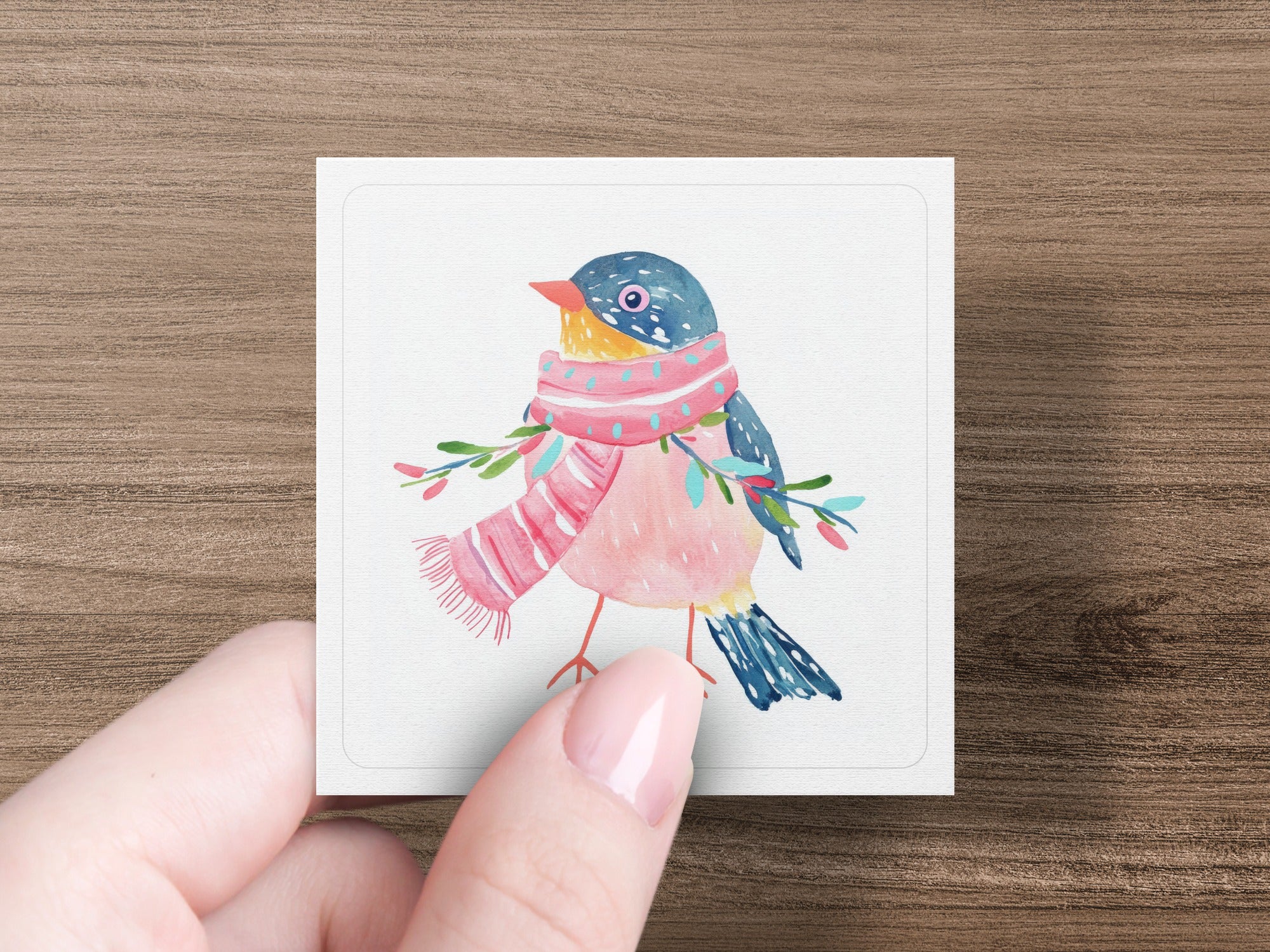 Watercolor bird with pink scarf and green branches on white card.