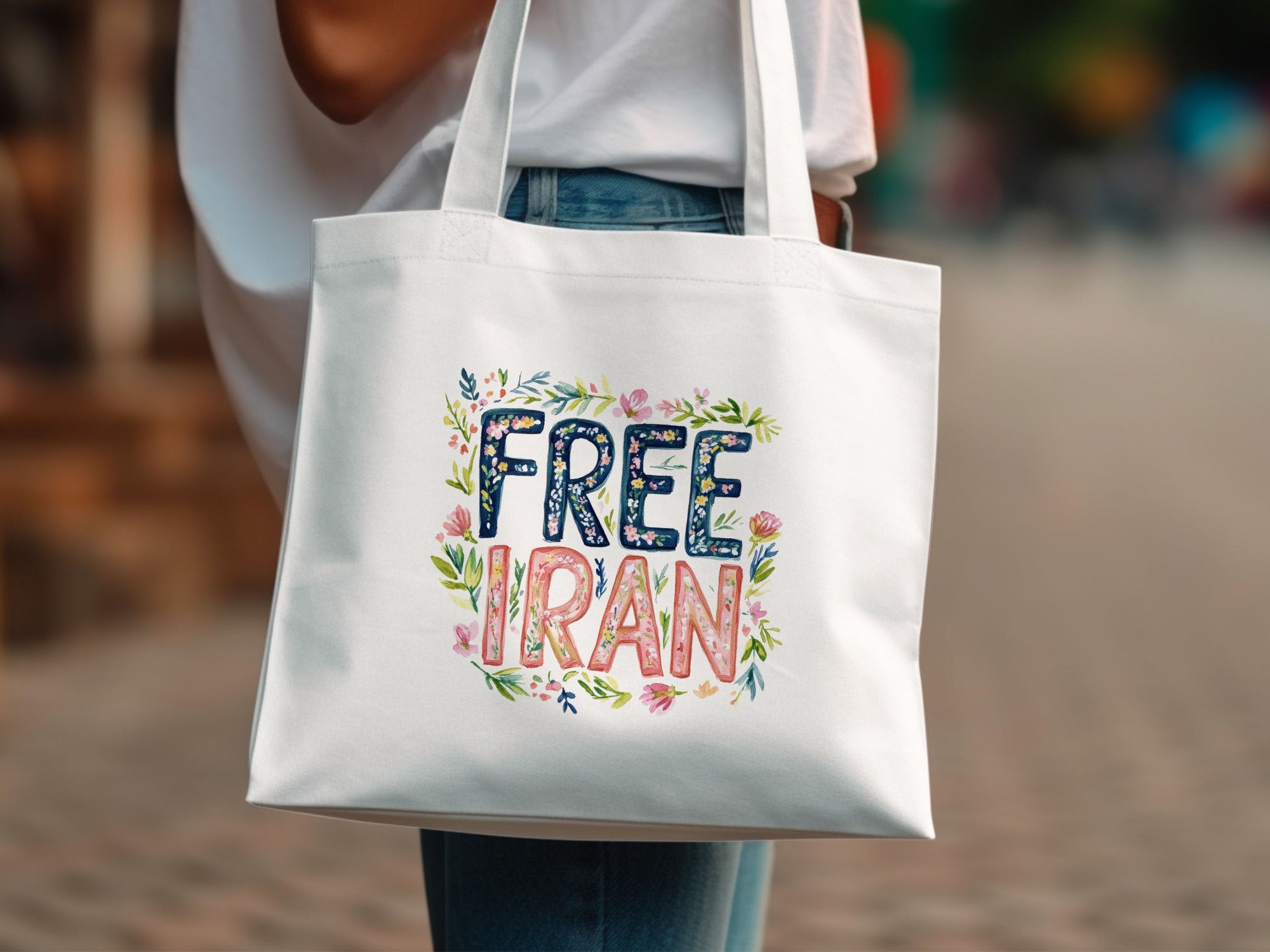 White tote bag with "Free Iran" text and floral illustrations.