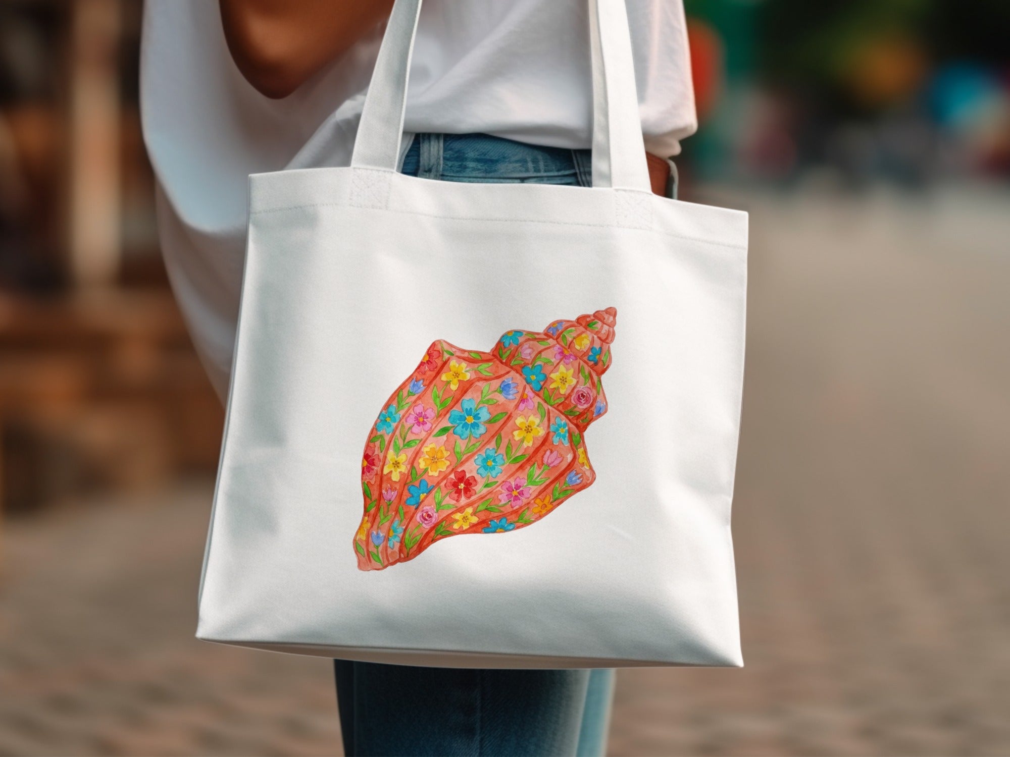 White tote bag with a colorful seashell illustration.