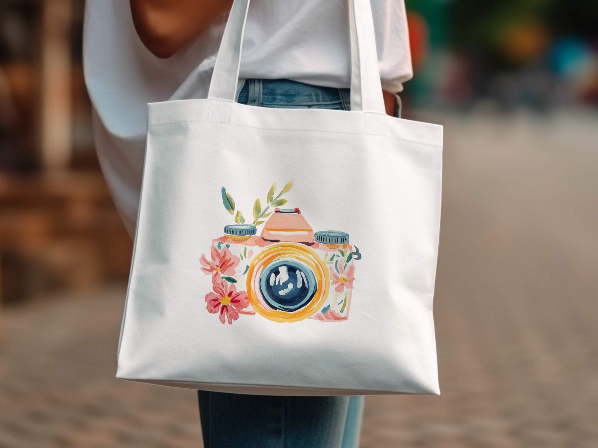 White tote bag with watercolor camera illustration of flowers.