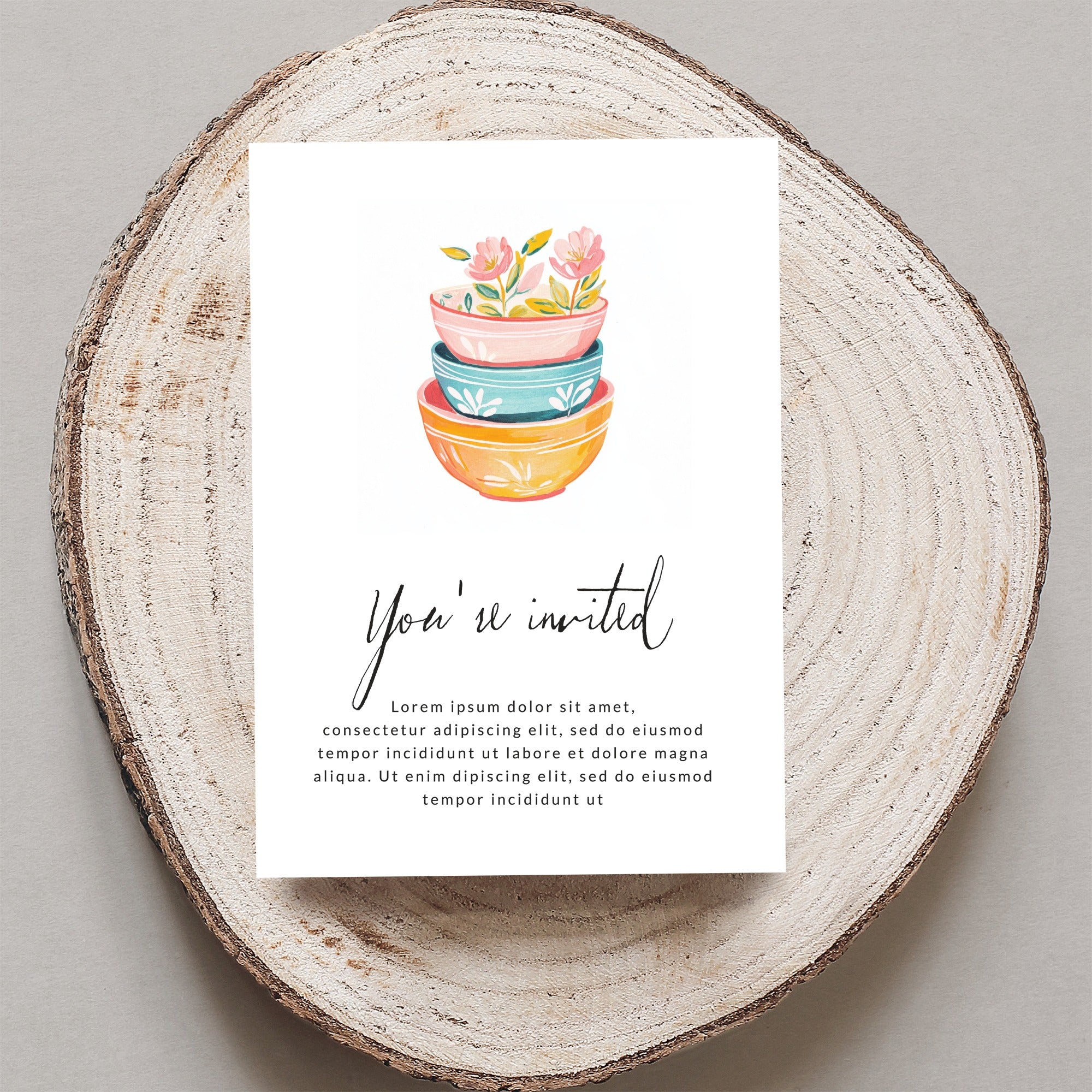 Invitation card with stacked colorful bowls and floral design, "You're invited" text.