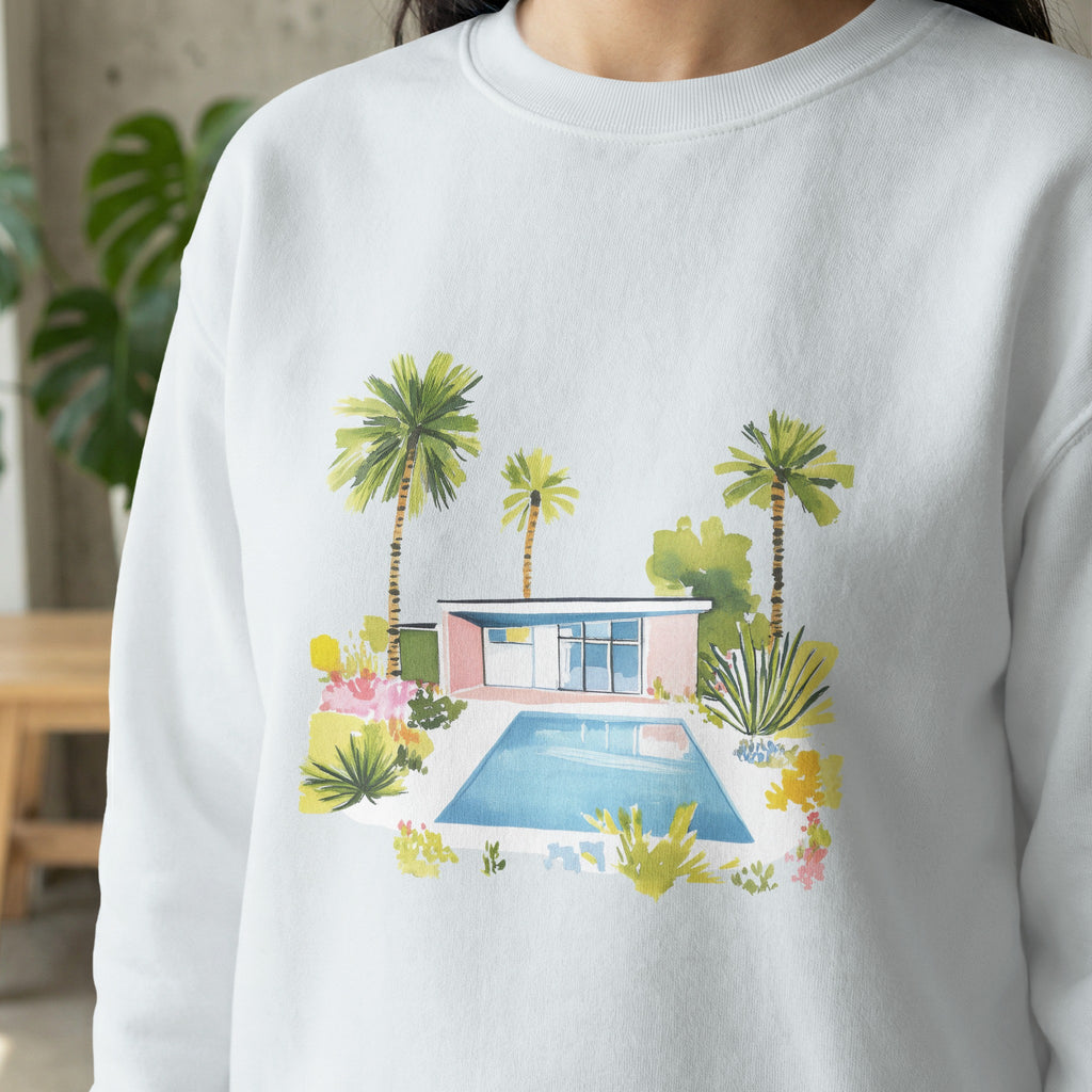 White sweatshirt with watercolor illustration of a mid-century modern home and pool.