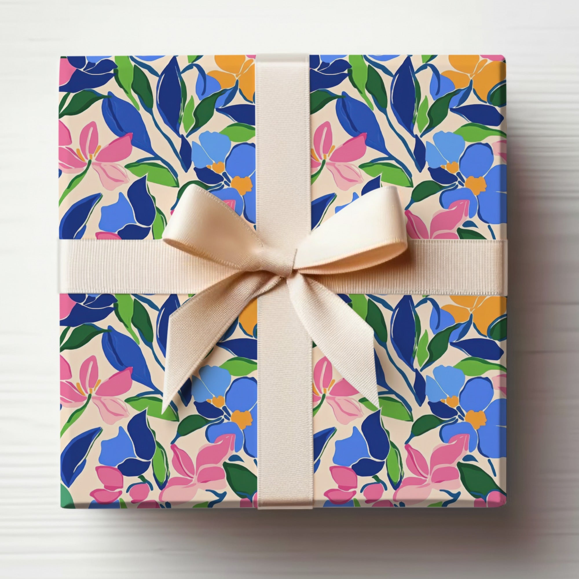 Gift-wrapped box with a floral pattern and a light brown ribbon.