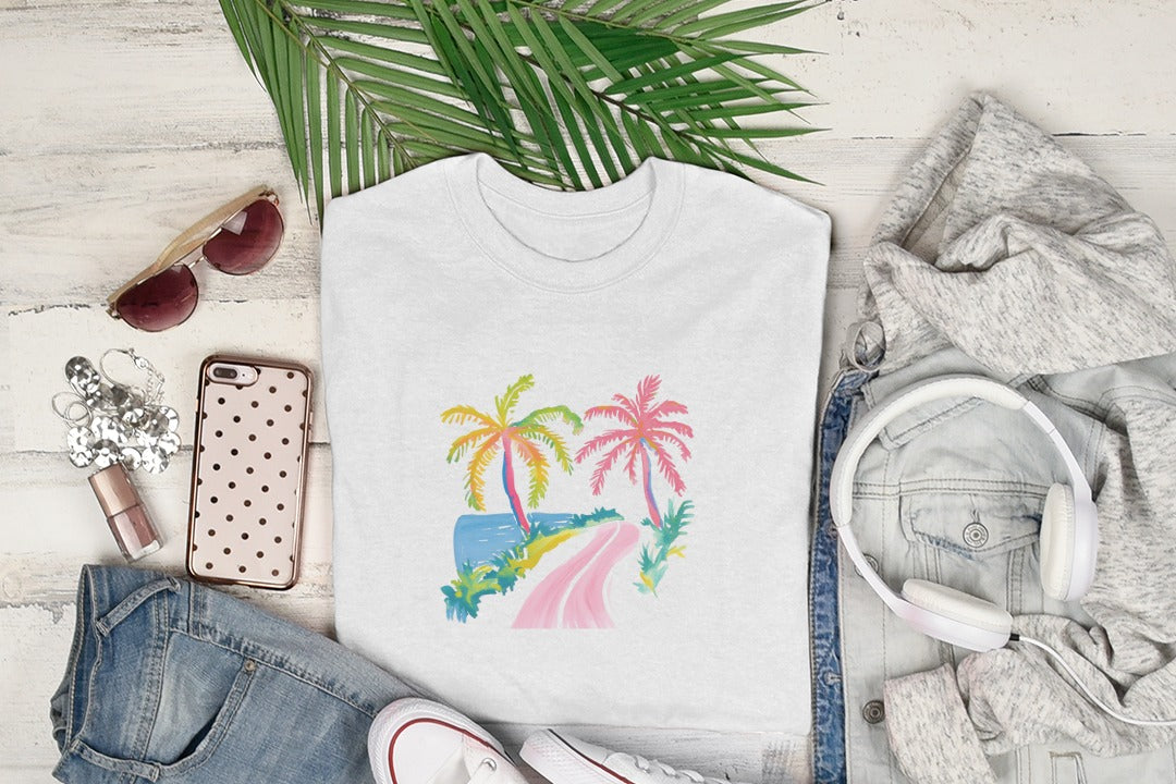 White t-shirt with colorful palm trees, ocean, and road graphic.