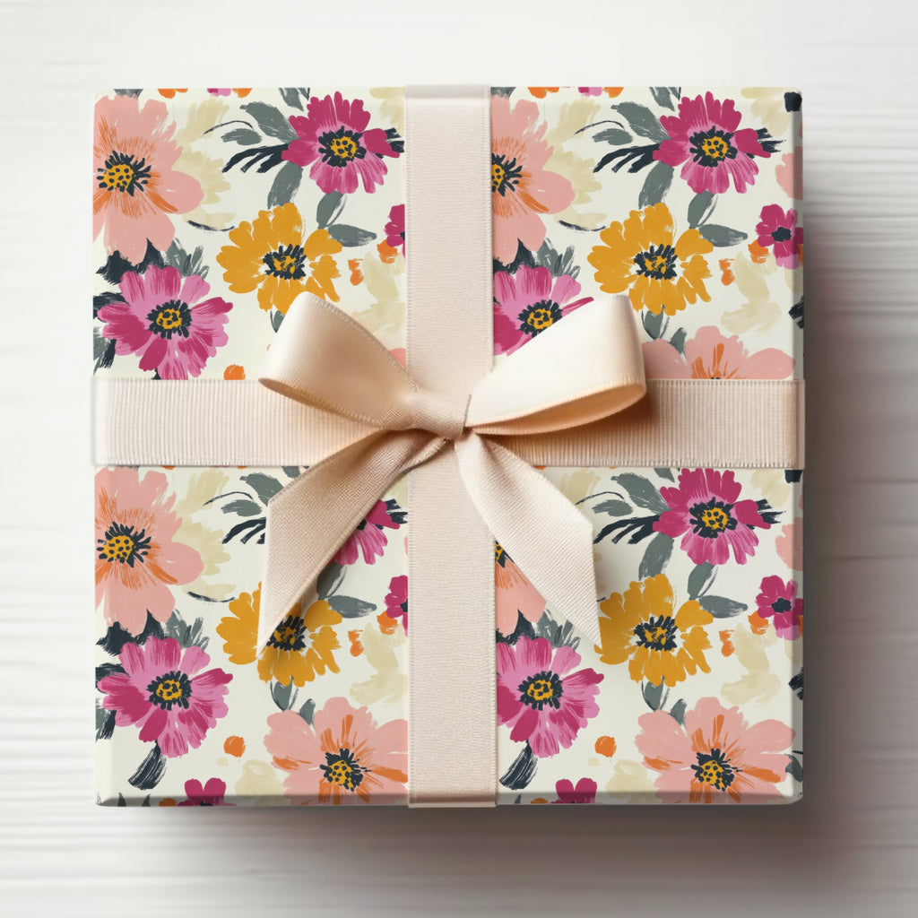 Gift-wrapped box with a pink and yellow floral pattern and a beige ribbon.