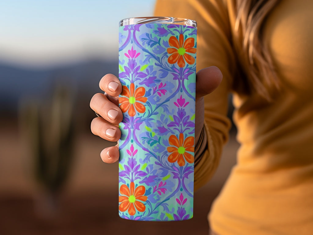 Purple and blue floral pattern on a tumbler held by a hand.