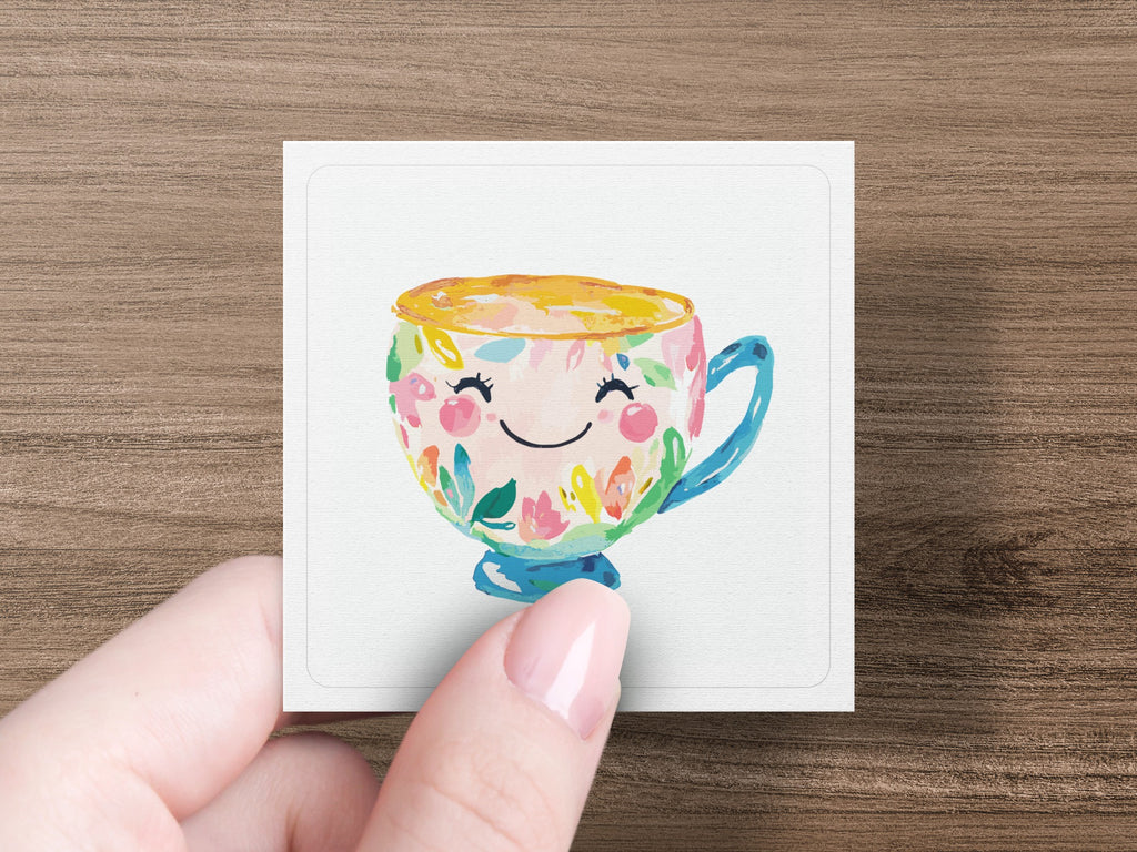 Smiling teacup with colorful floral pattern, held by a hand.