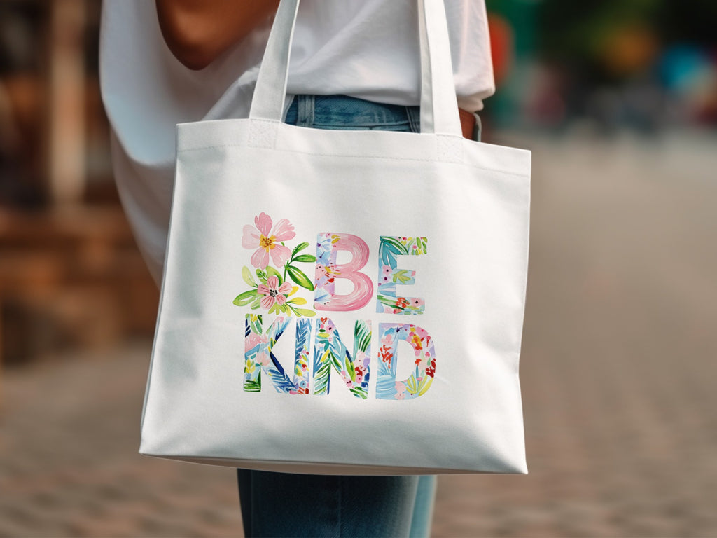 White canvas tote bag with "BE KIND" in floral watercolor lettering.