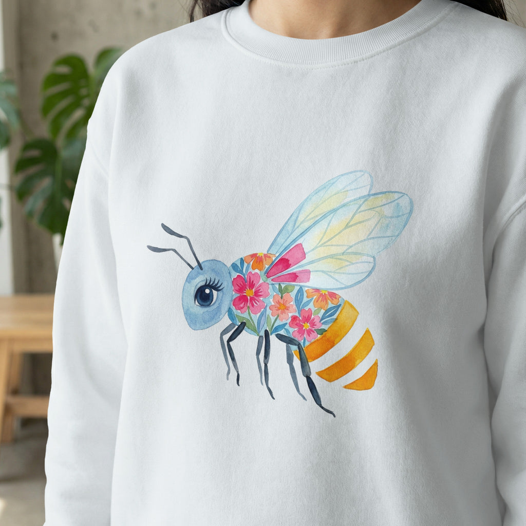 Watercolor bee with floral wings and orange stripes on a white sweatshirt.