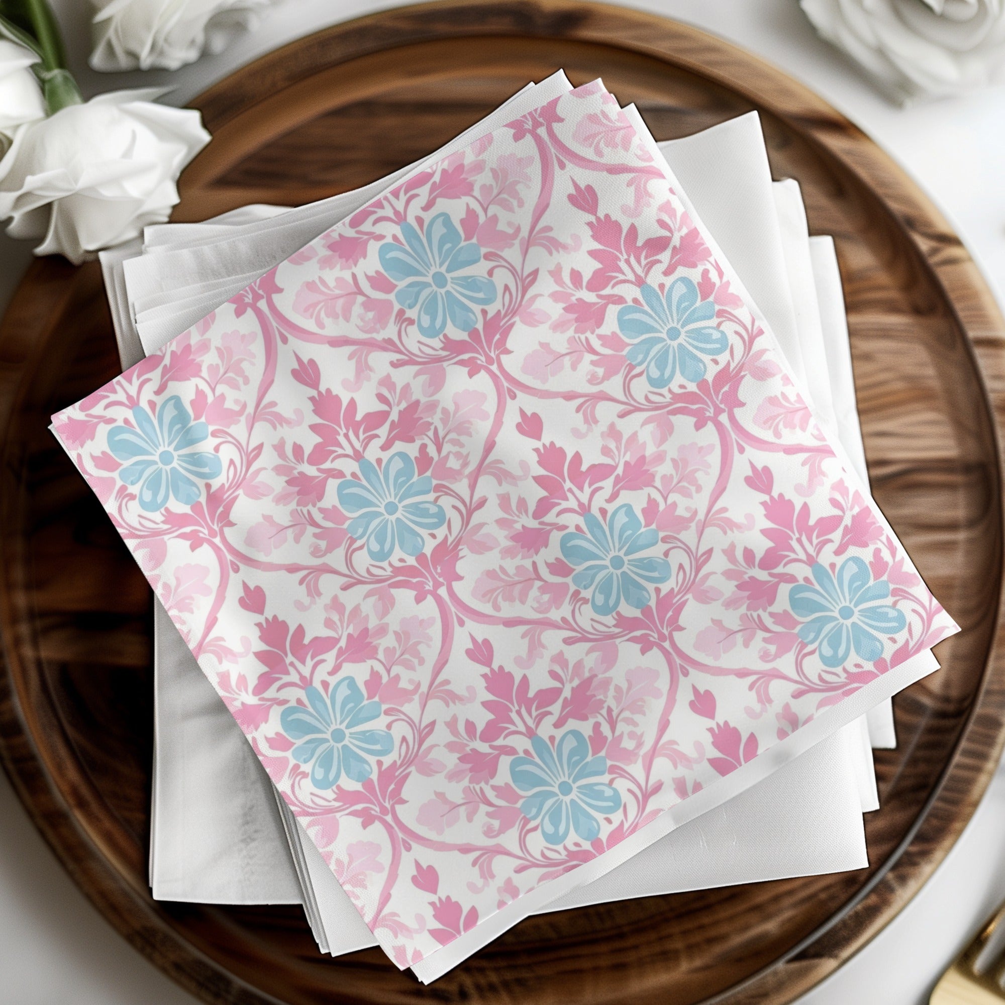 Pink and blue floral patterned napkins folded on a wooden platter.