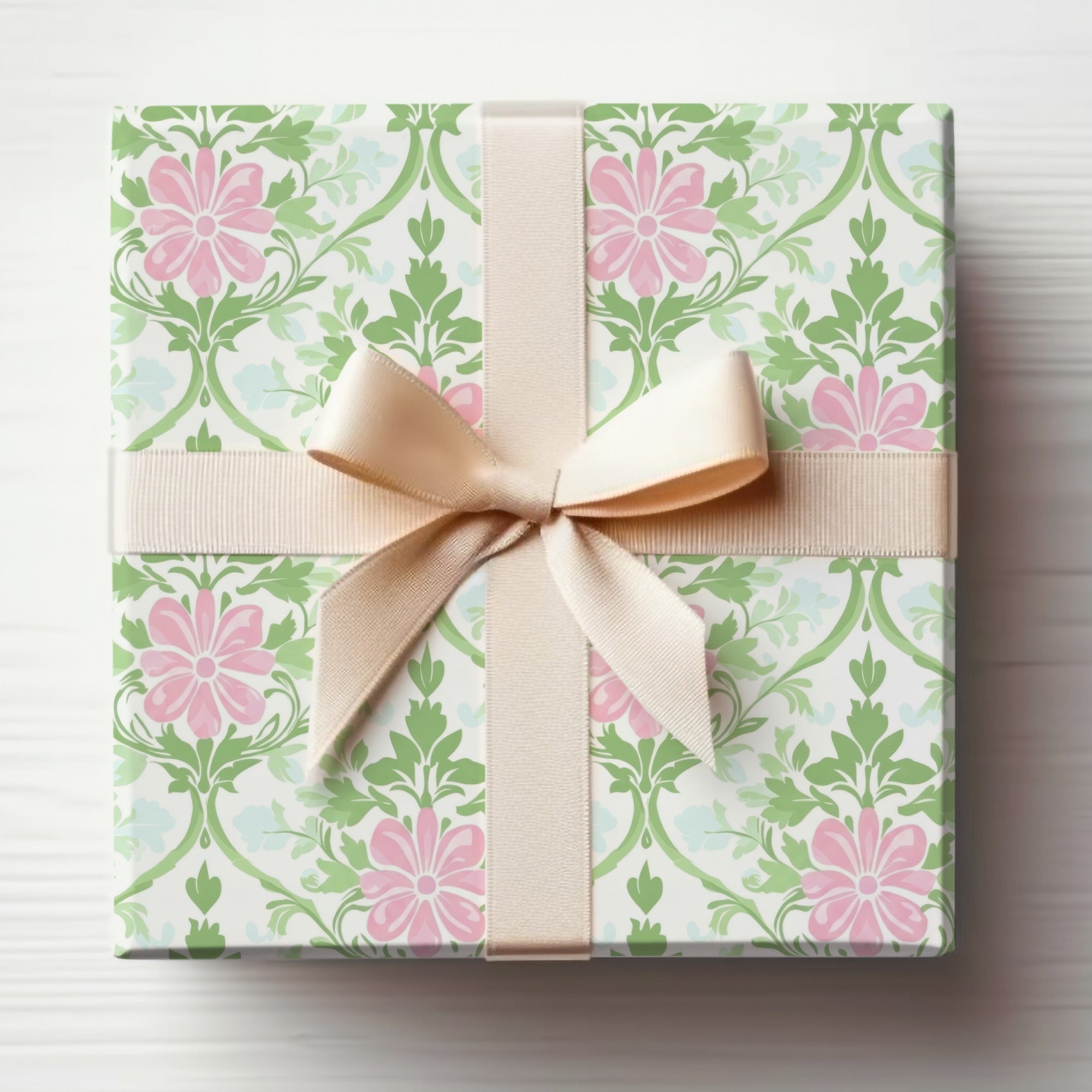 Gift box wrapped in floral paper with a pale pink ribbon tied in a bow.