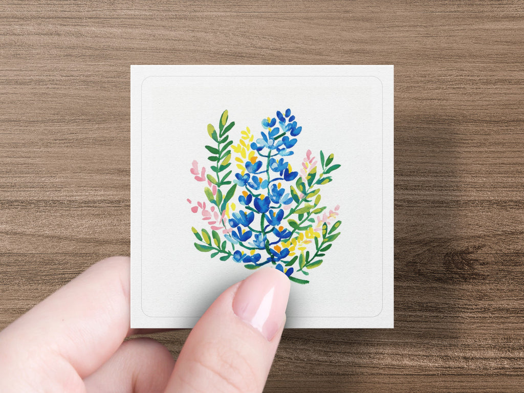 Watercolor floral illustration of blue and yellow wildflowers on a white card.