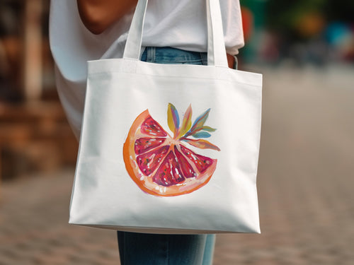 White canvas tote bag with a painted slice of grapefruit and leaves.