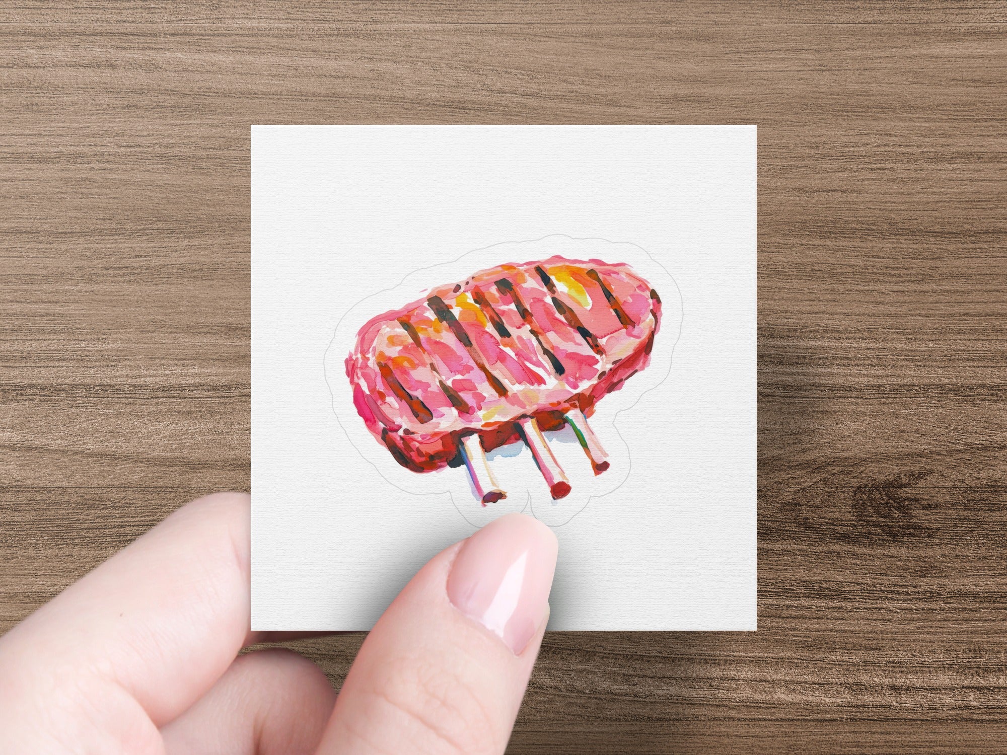 Cooked rack of lamb with visible grill marks held by a hand.