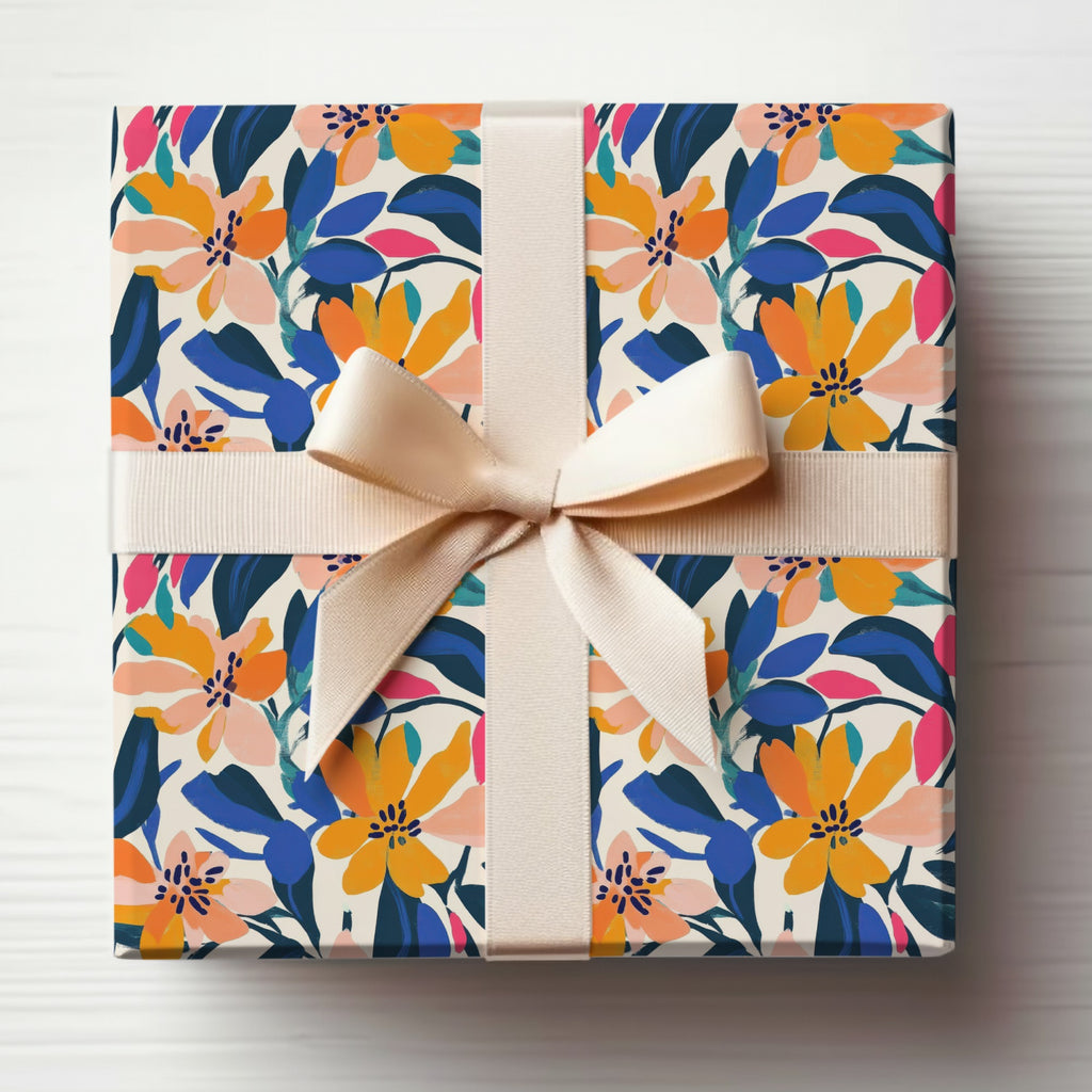 Gift box wrapped in colorful floral paper with a beige ribbon bow.