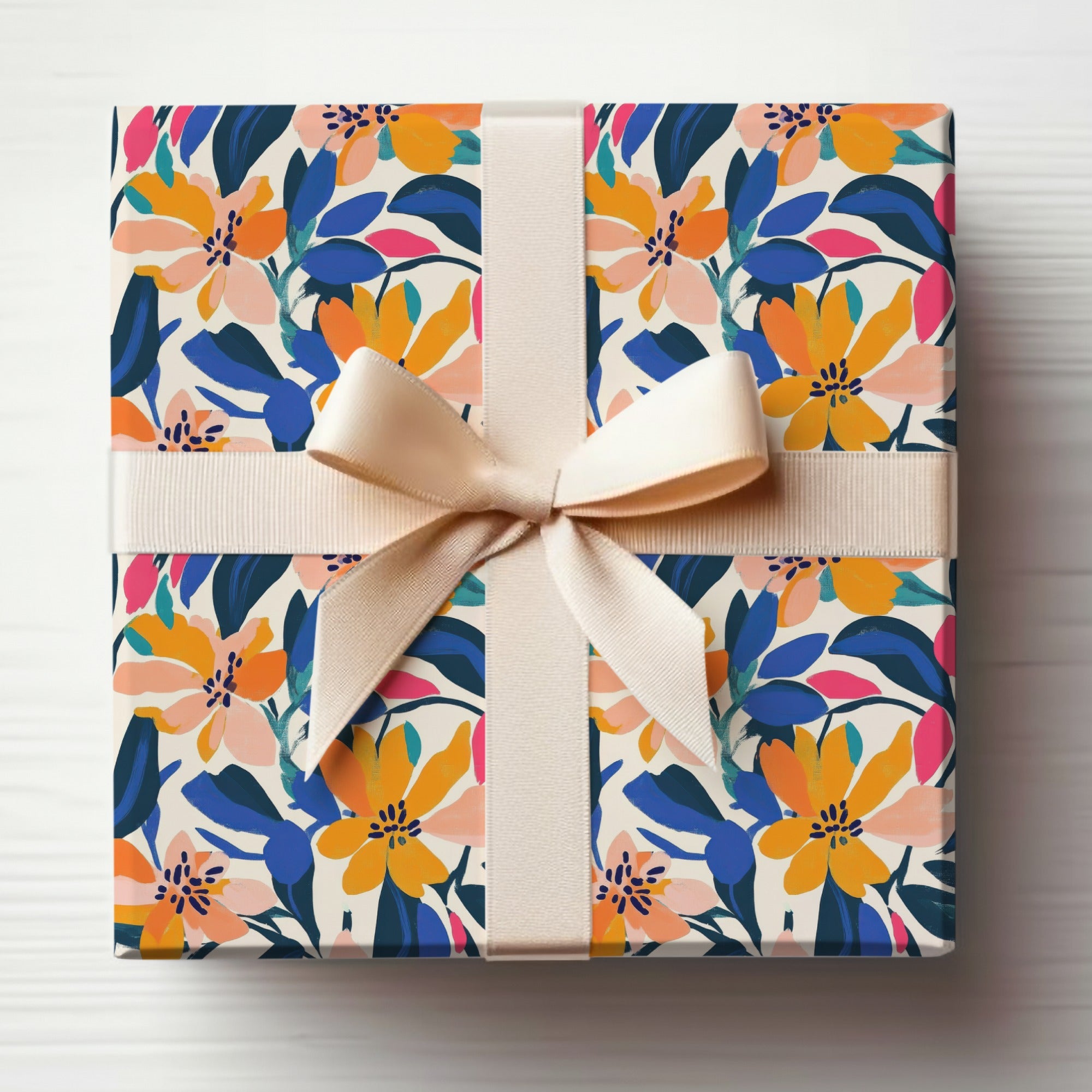 Gift box wrapped in colorful floral paper with a beige ribbon bow.
