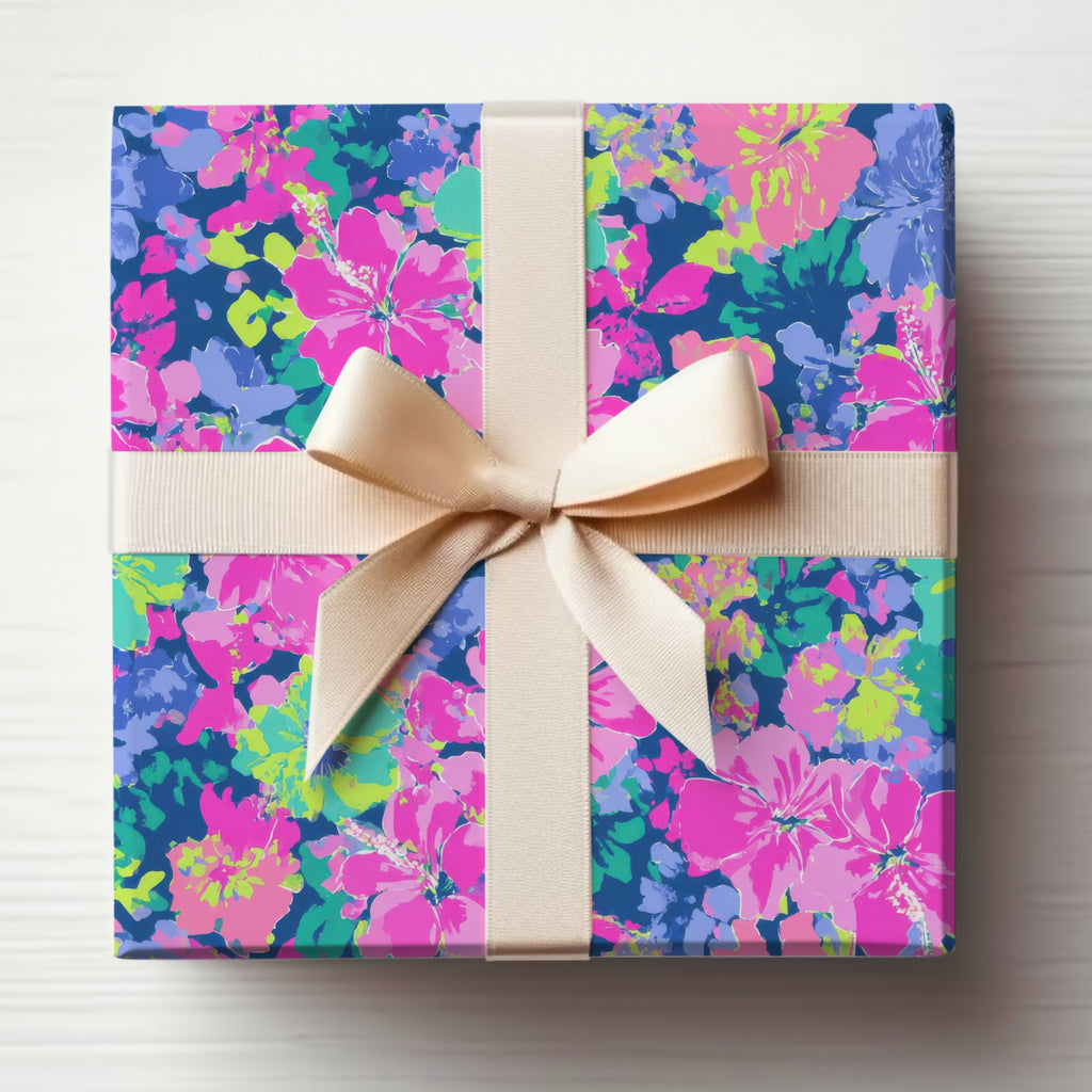 Gift box with beige ribbon and vibrant floral pattern on blue background.