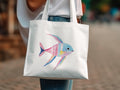 White tote bag with a watercolor painting of a colorful, tropical fish.