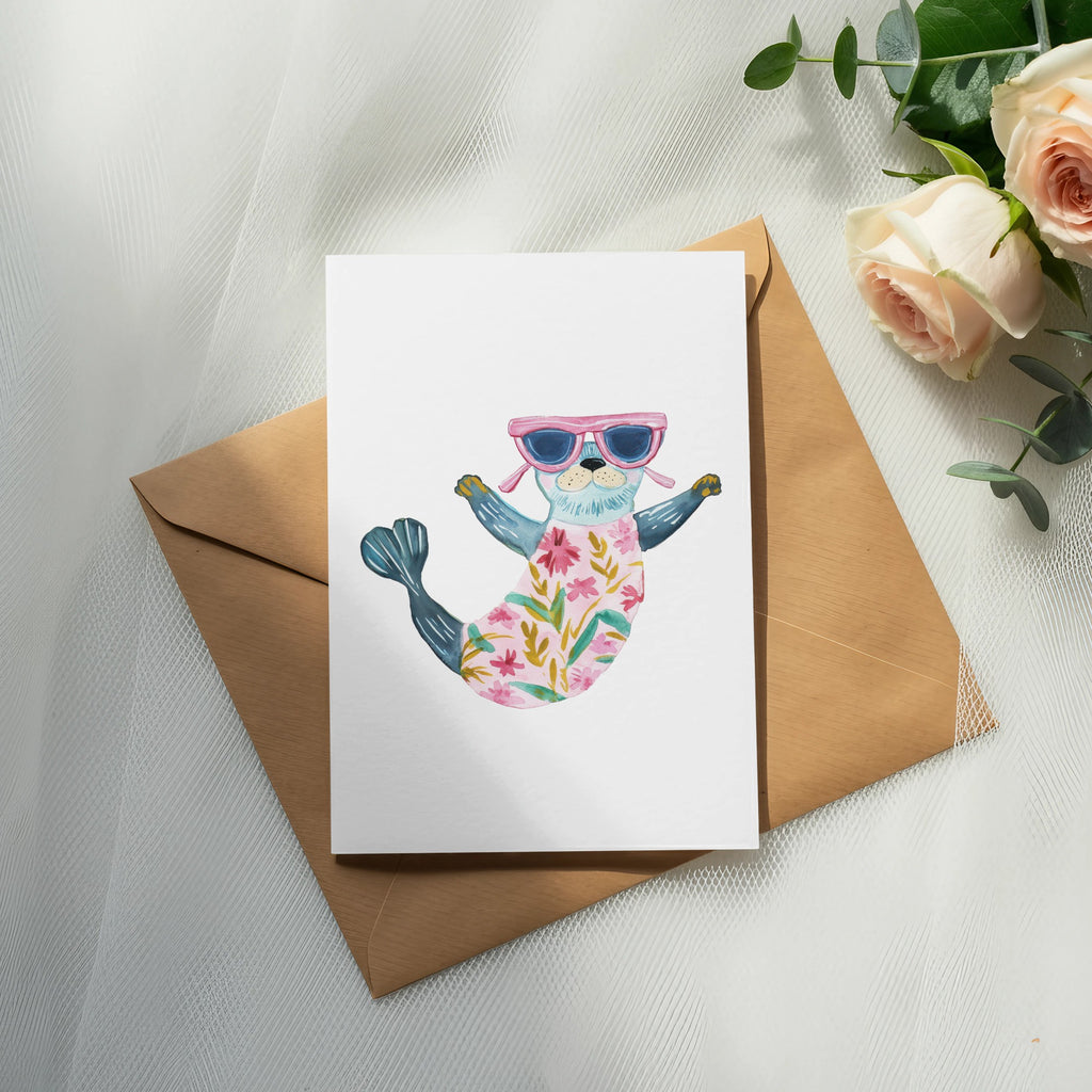 Watercolor illustration of a seal wearing sunglasses and a floral swimsuit on a card.