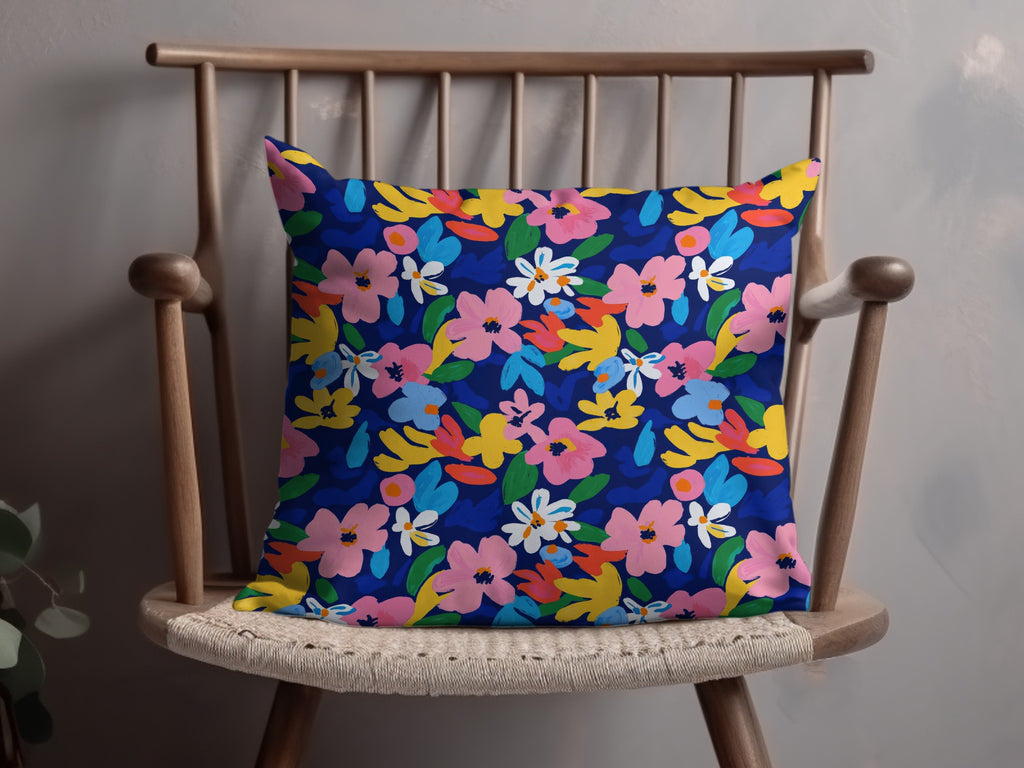 Blue throw pillow with a vibrant, abstract floral pattern.