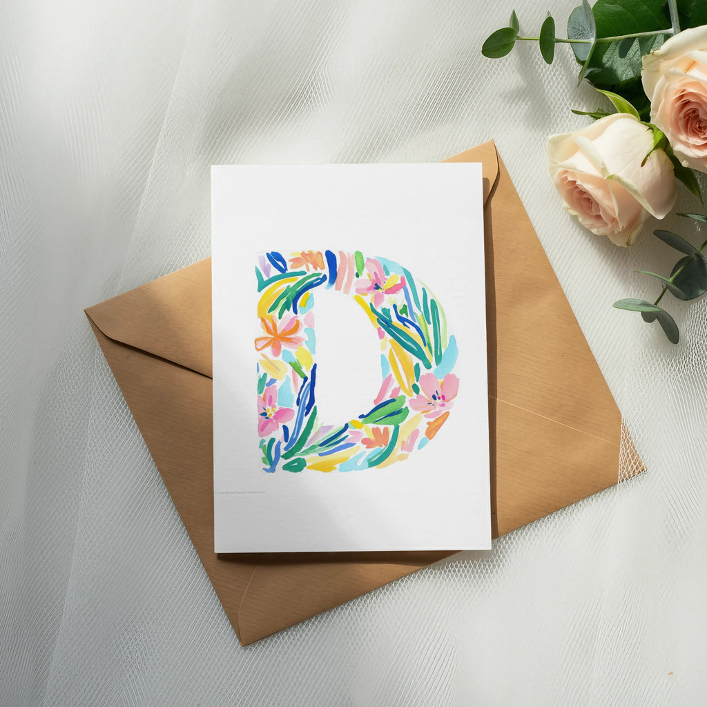 Card with a colorful floral letter "D" on a brown envelope.