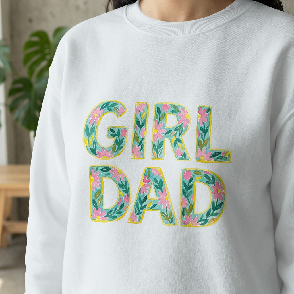 White sweatshirt with "GIRL DAD" in floral lettering.