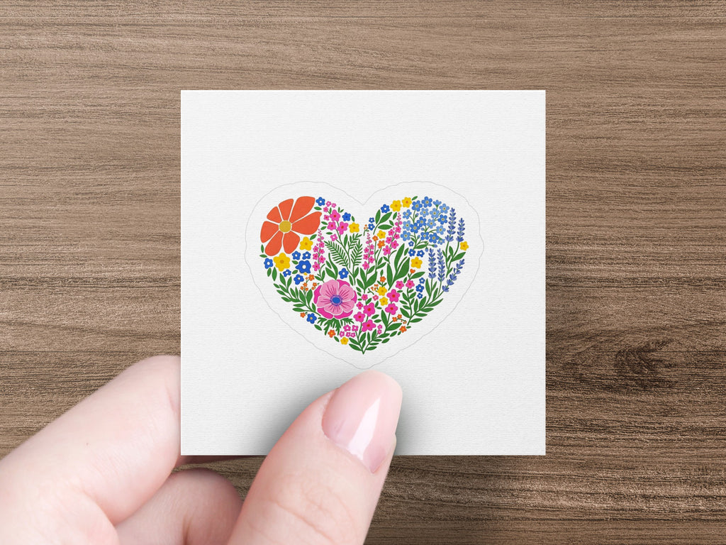 Heart-shaped sticker with colorful flowers and greenery.