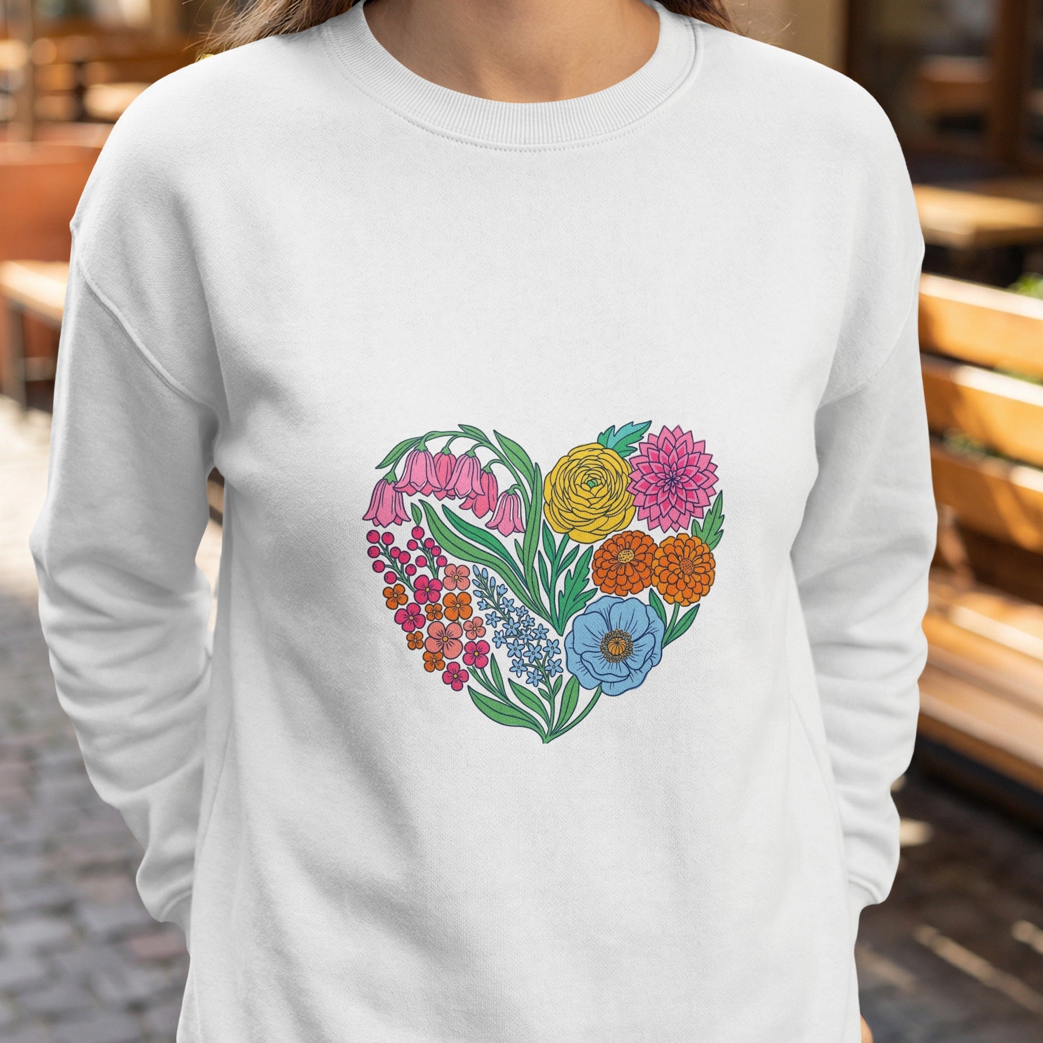 White sweatshirt with a colorful heart-shaped floral design.