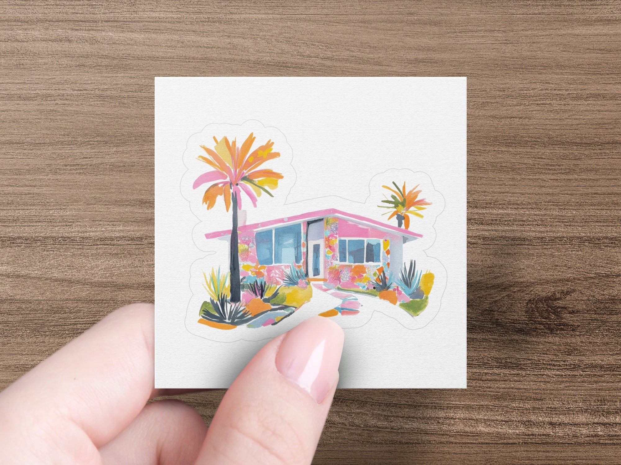 Pink mid-century modern house with palm trees and colorful landscaping.