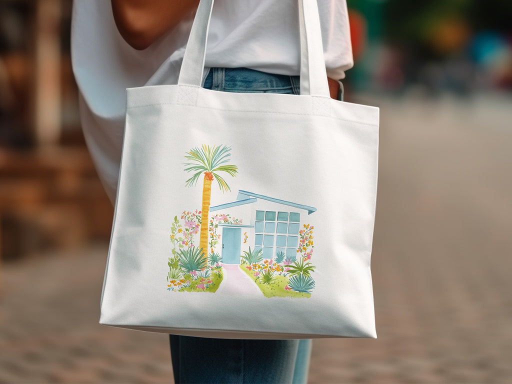 White canvas tote bag with watercolor illustration of a mid-century modern house.