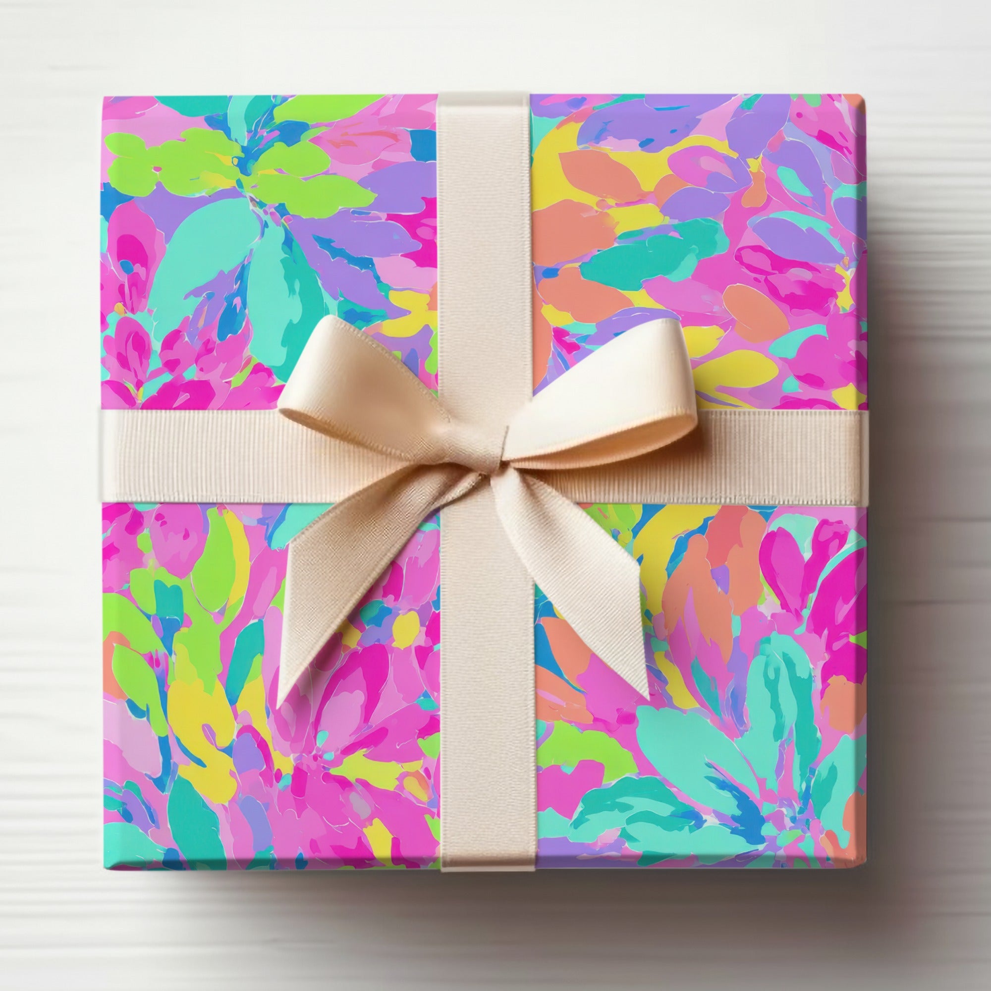 Gift box wrapped in colorful floral pattern with cream ribbon bow.