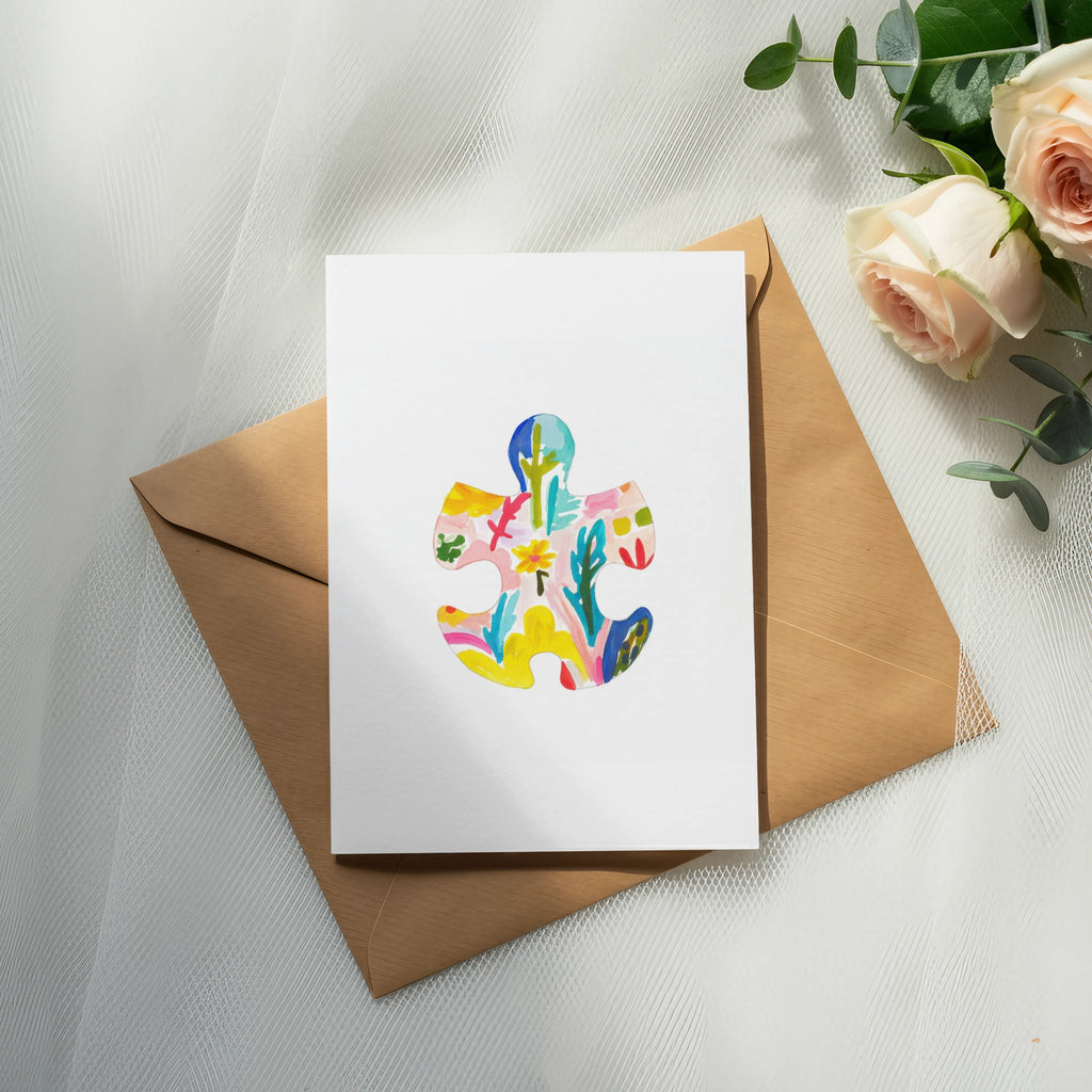Card with colorful abstract puzzle piece design on kraft envelope.