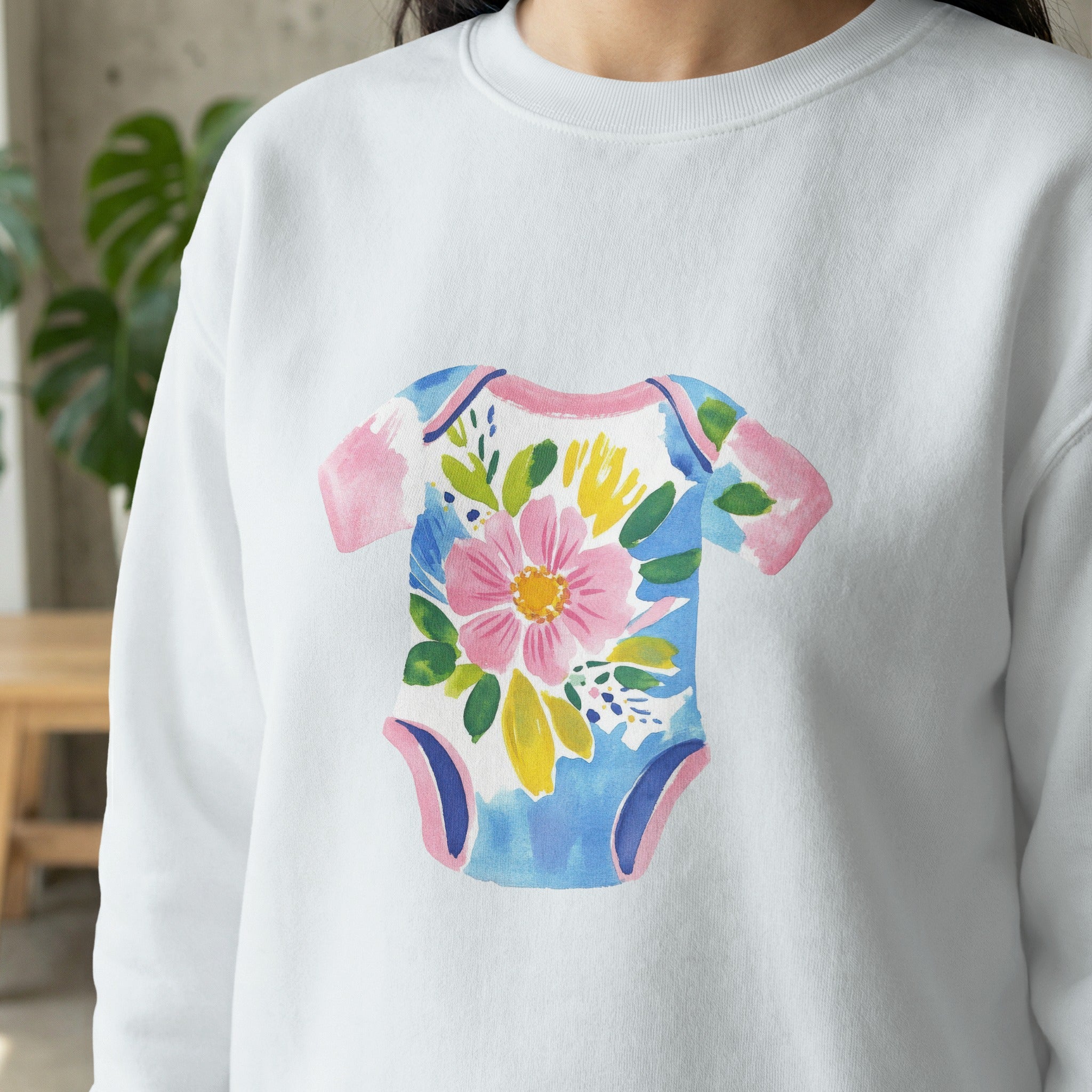 White sweatshirt with a watercolor floral baby onesie print.