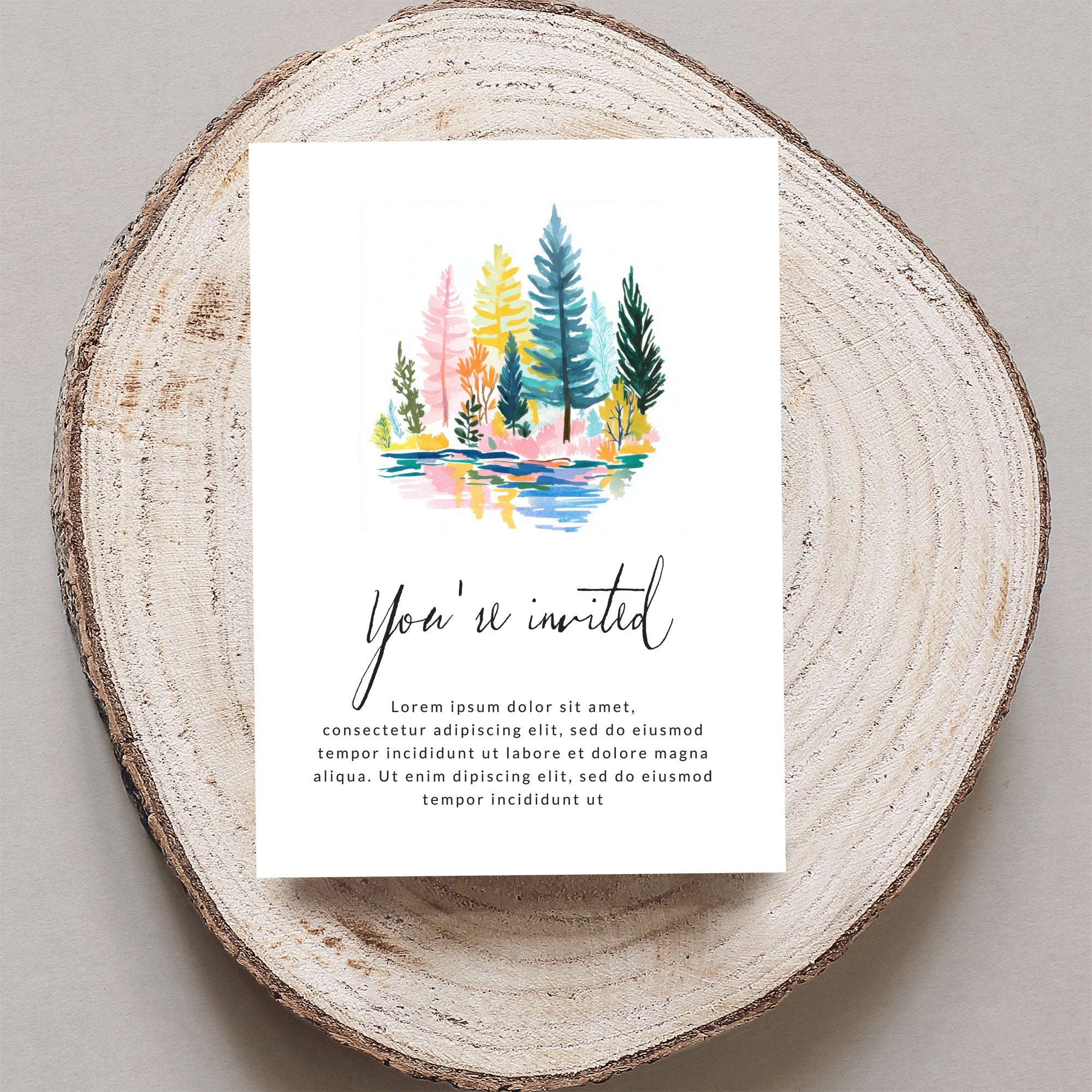 Invitation with colorful watercolor trees and reflective water, reads "You're invited"