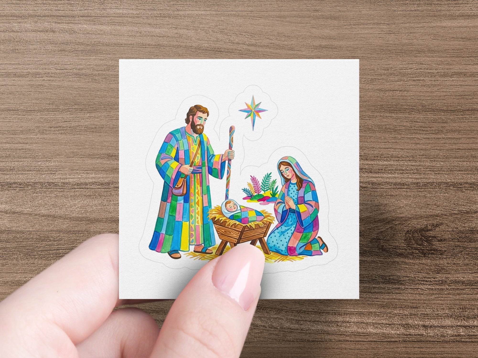 Nativity scene sticker with Mary, Joseph, and baby Jesus in a manger.