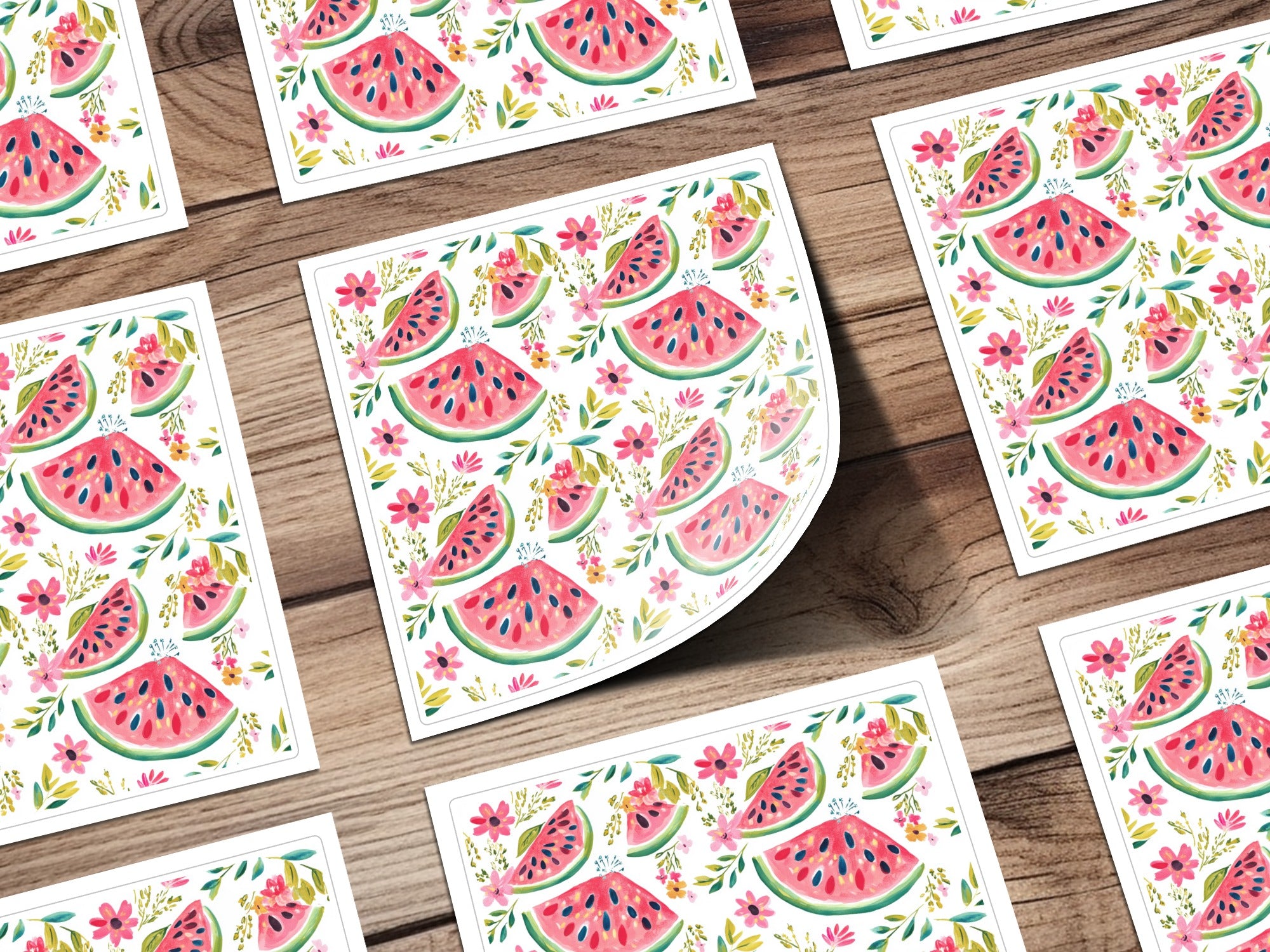 Watermelon slice and flower pattern on square cards arranged on a wooden surface.