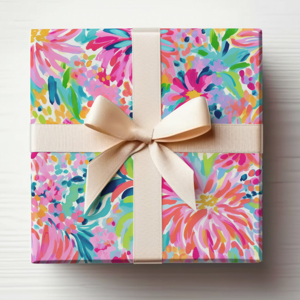 Gift box wrapped in bright floral paper tied with a cream ribbon.