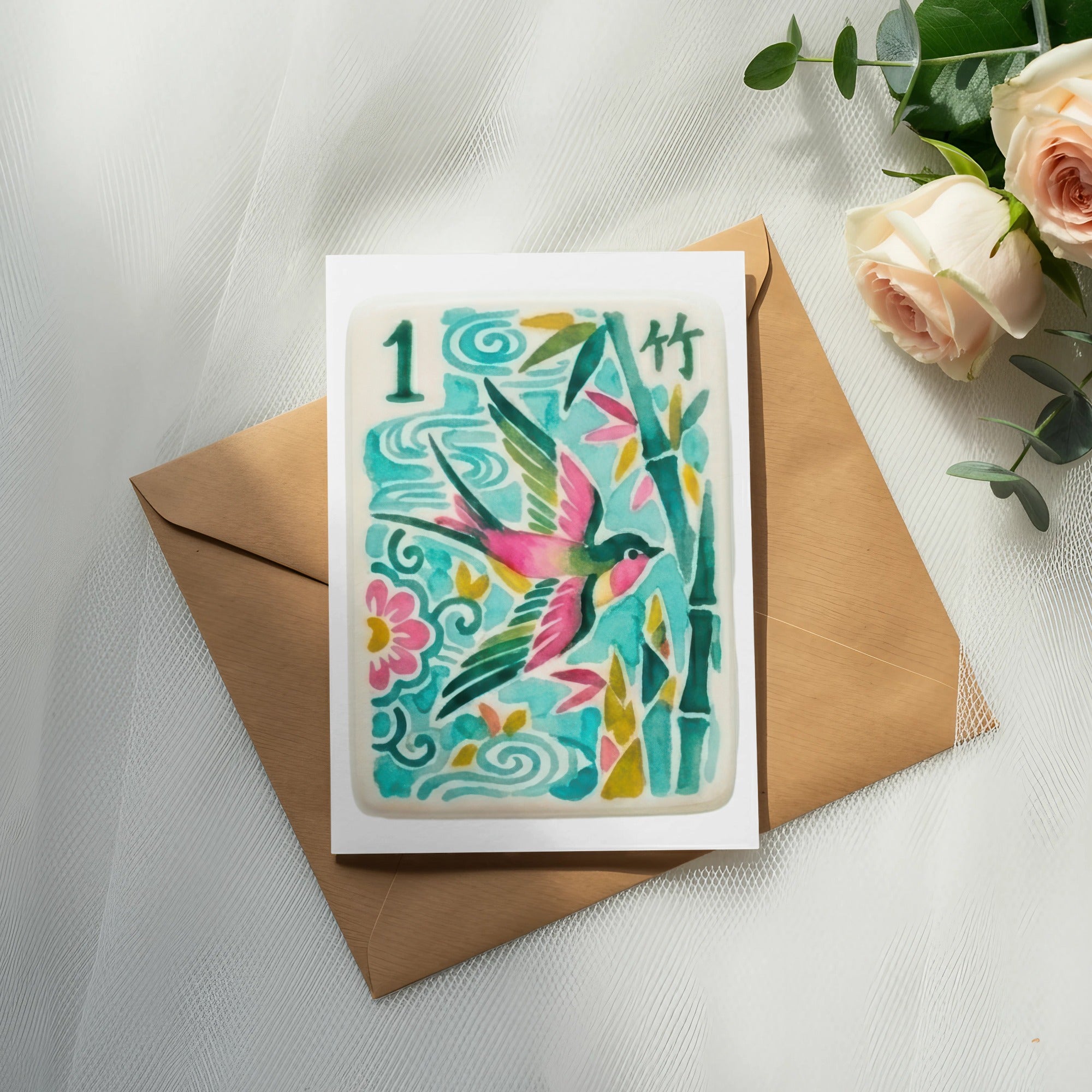 Card with bird and bamboo design on brown envelope, with roses and eucalyptus.