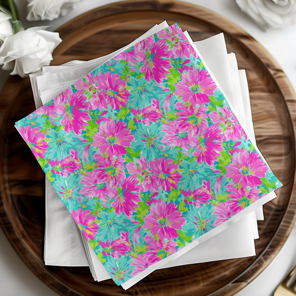 Pink and teal floral pattern on white napkins on a wooden tray.