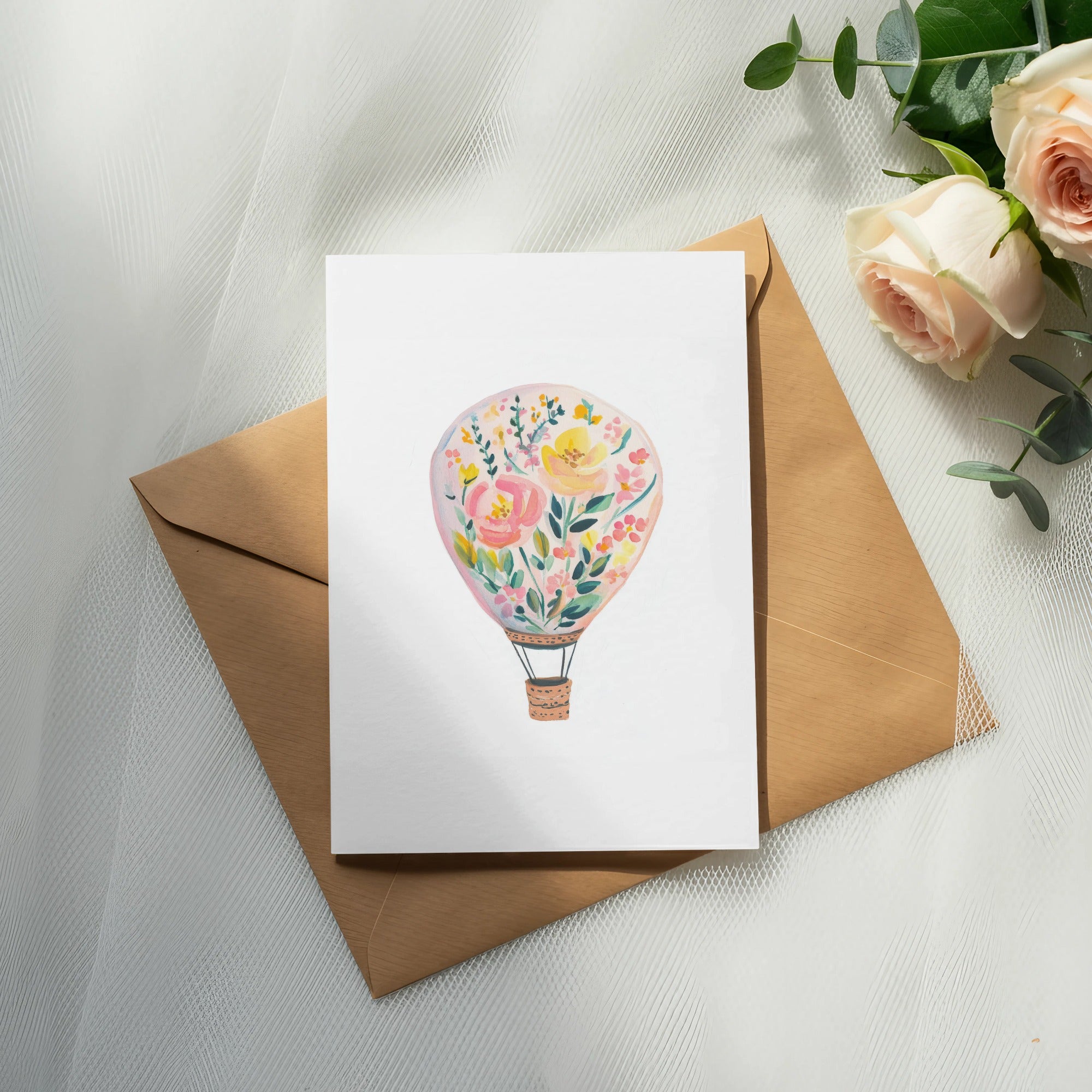 White card with floral hot air balloon design on brown envelope.