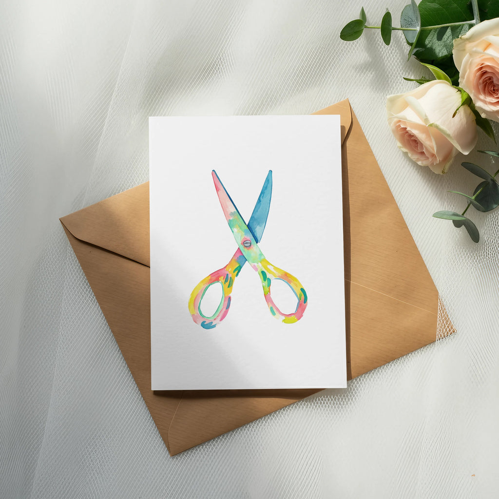 Colorful scissors on a card atop a brown envelope.