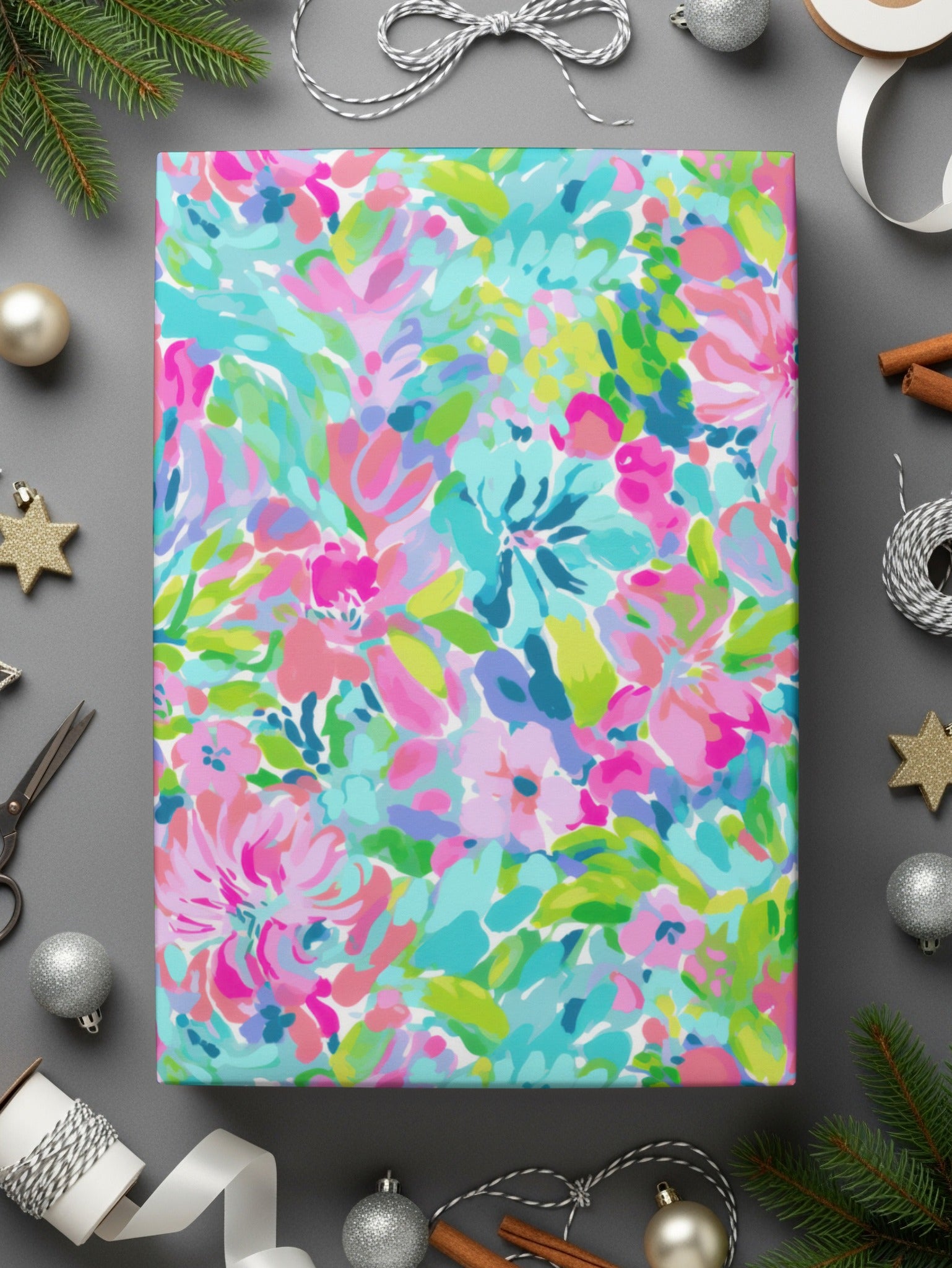 Colorful floral wrapping paper with silver ribbon and ornaments on gray background.