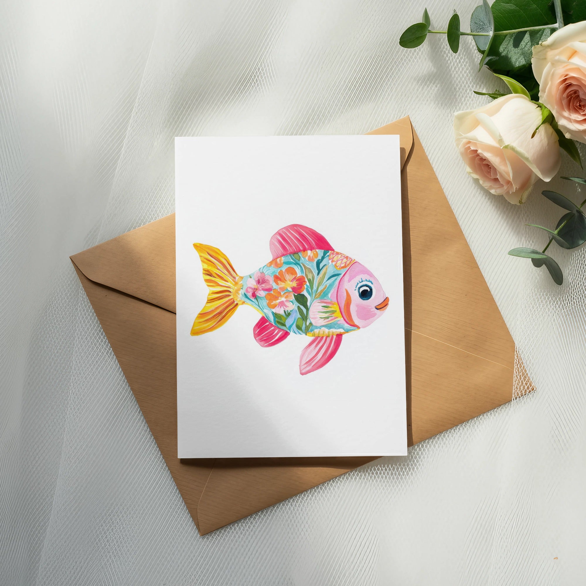 Colorful floral fish illustration on a card with a brown envelope and roses.